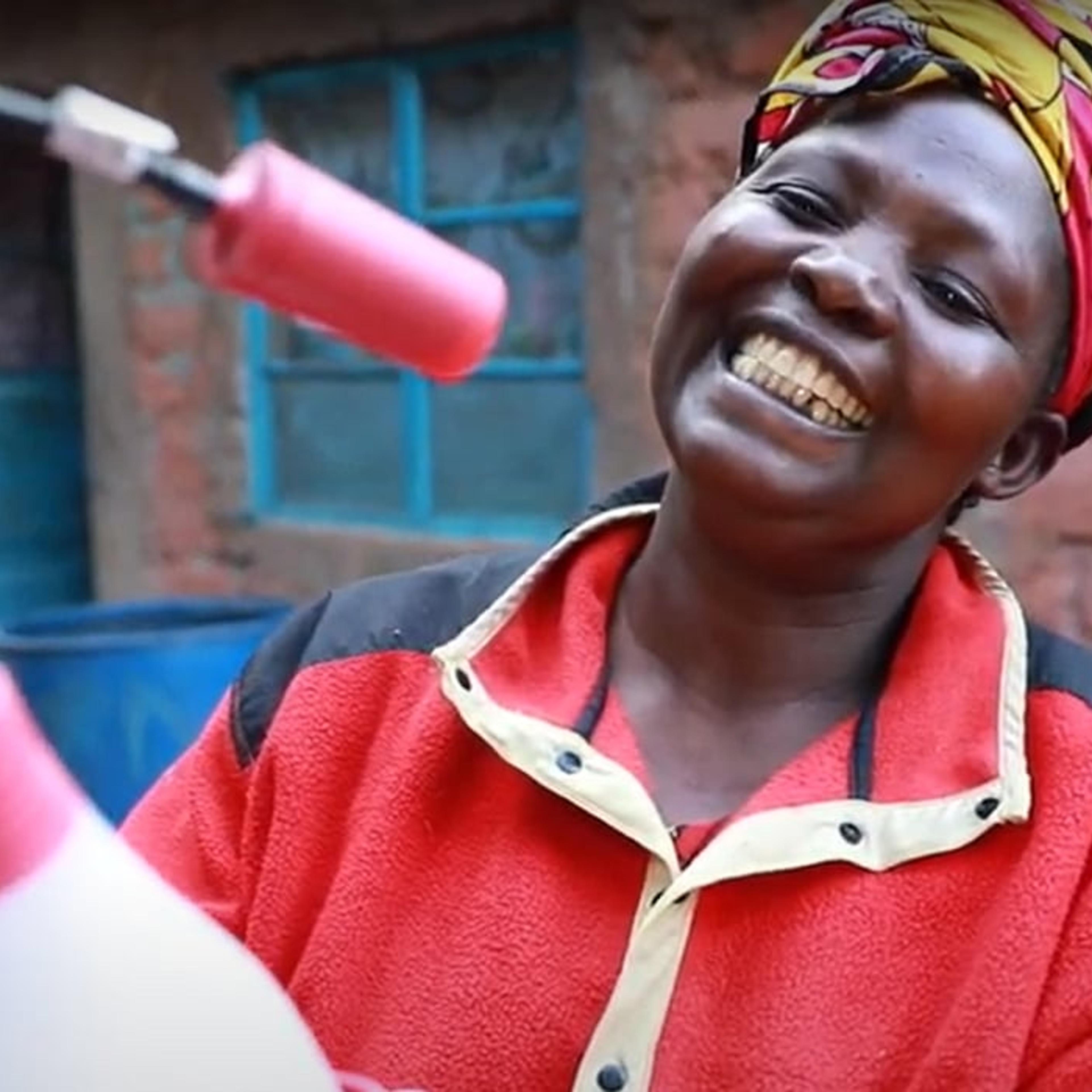 Glad afrikansk dame som holder solcelledrevet lampe