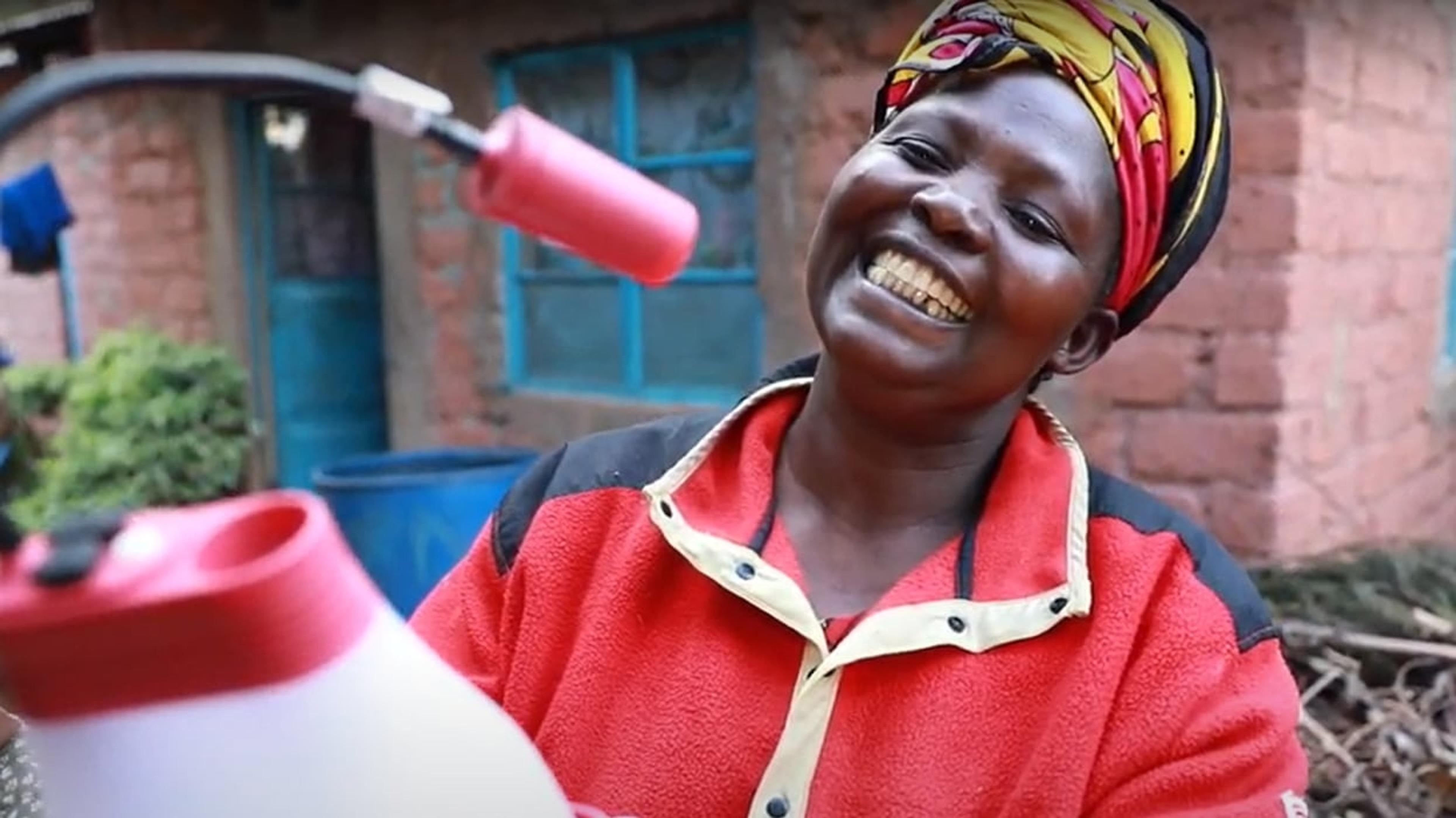 Glad afrikansk dame som holder solcelledrevet lampe