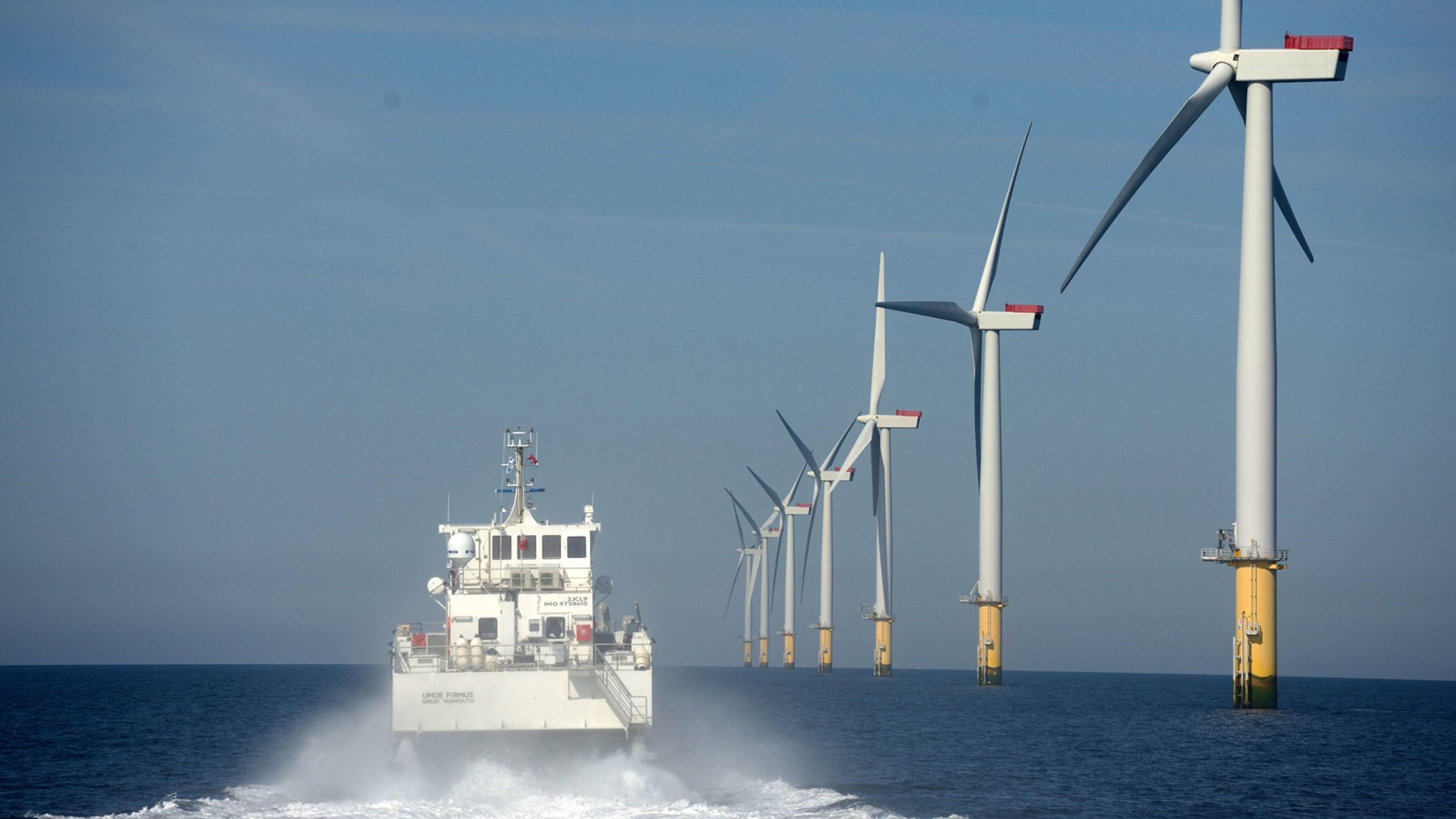 Skip som passerer vindmøllepark til havs