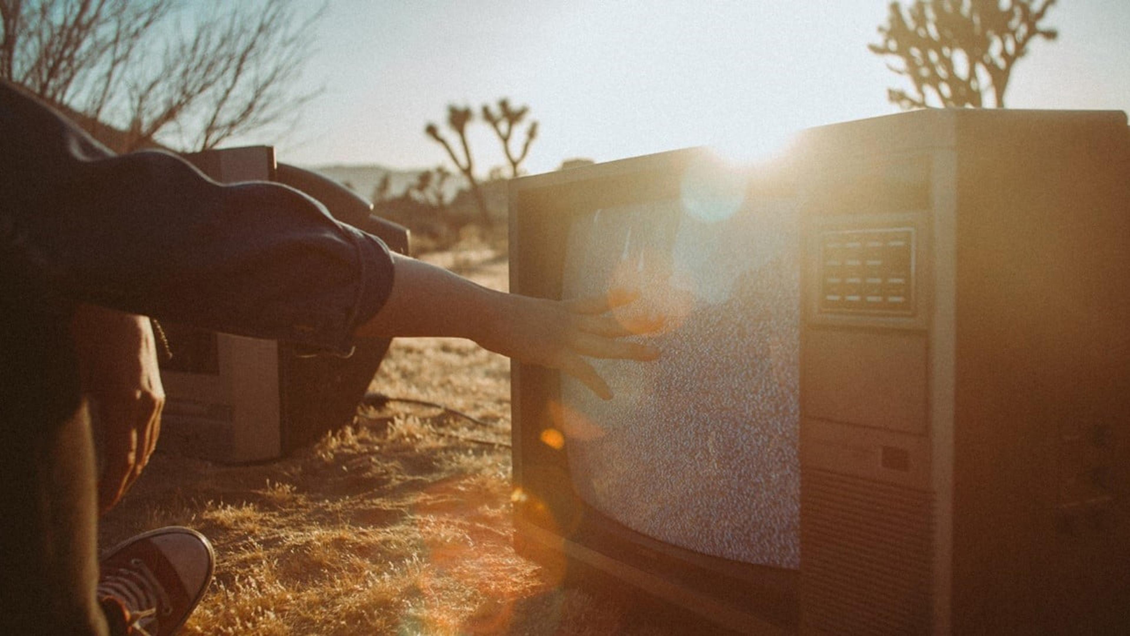 Menneske som ser på gammel TV i ørkenen