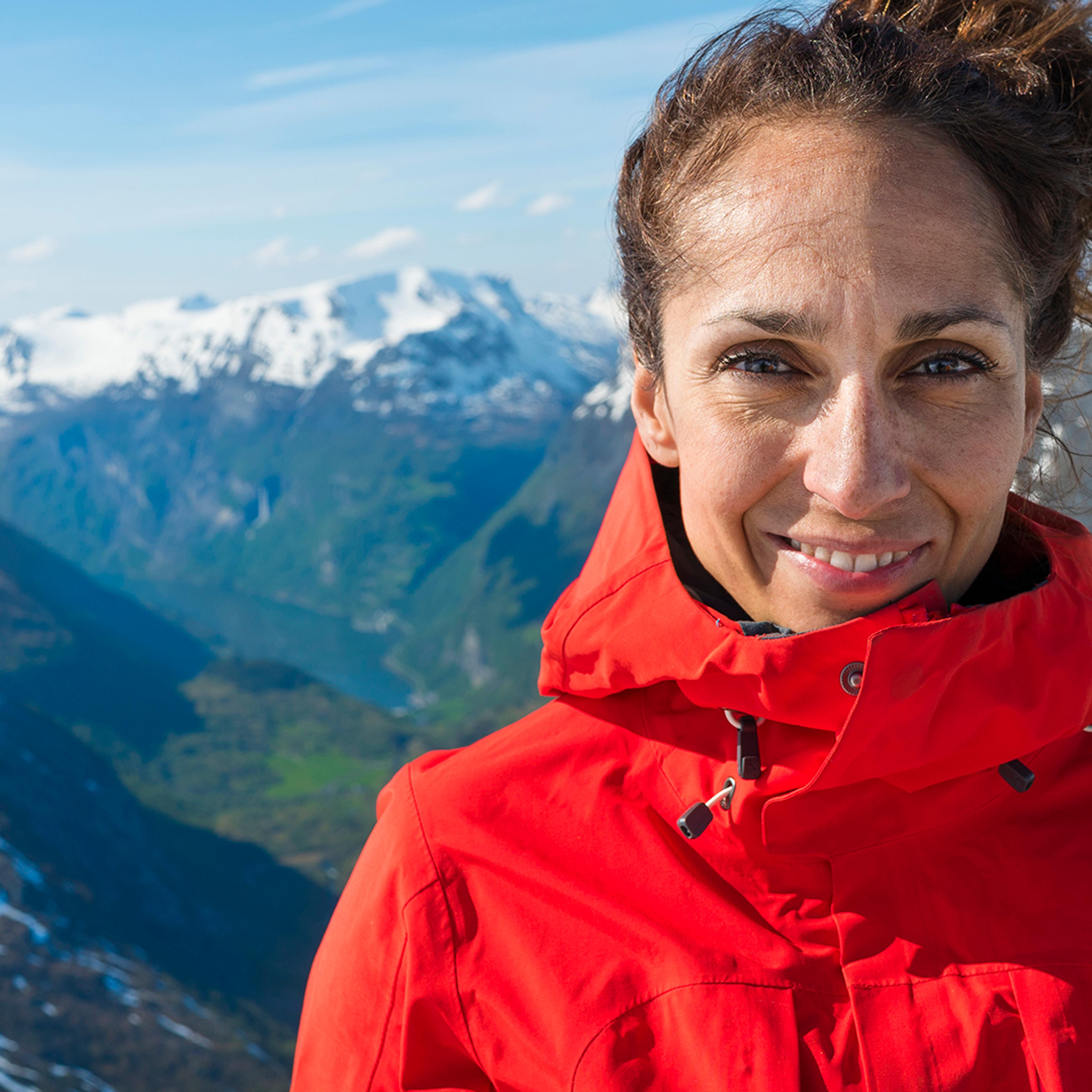 Woman in red jacket on top of mountain