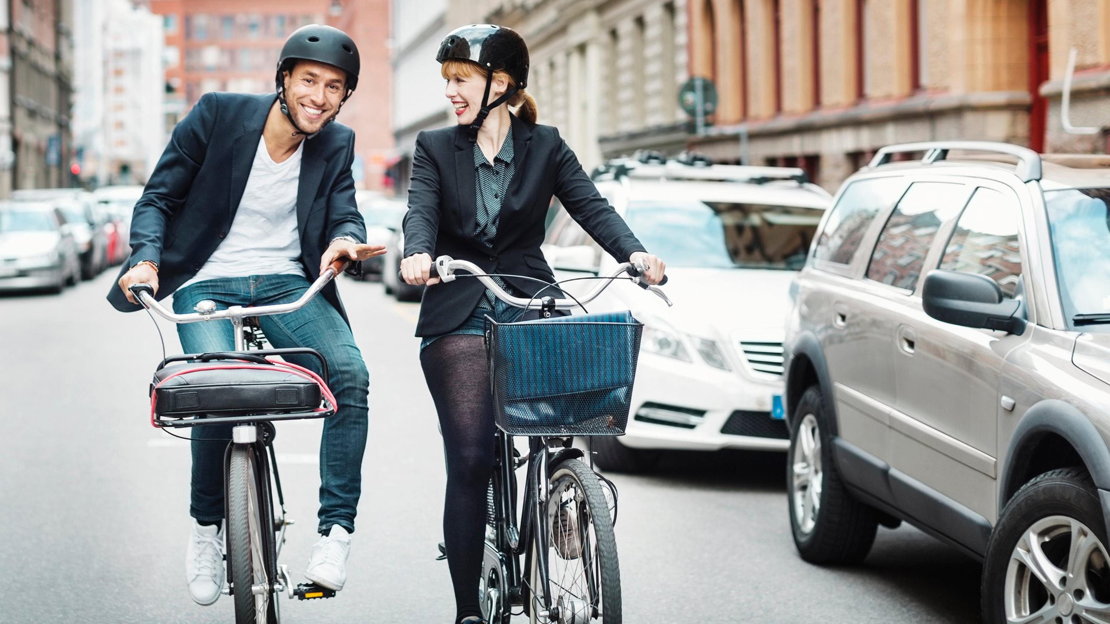 Glade forretningsfolk som sykler på bygate