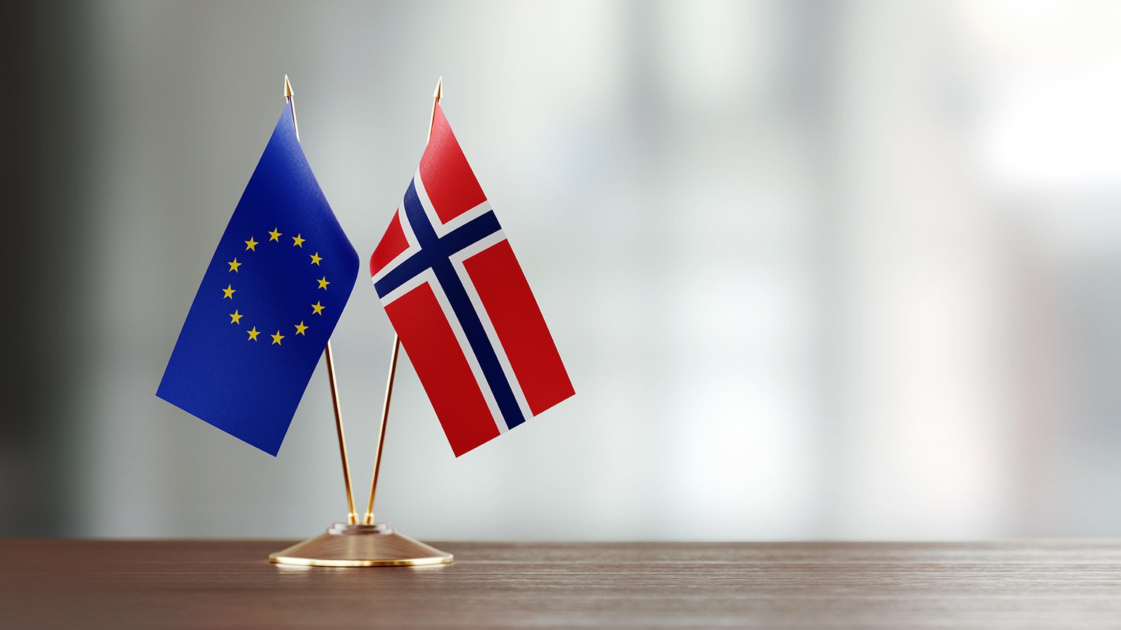 Norsk flagg og EU-flagg på et bord