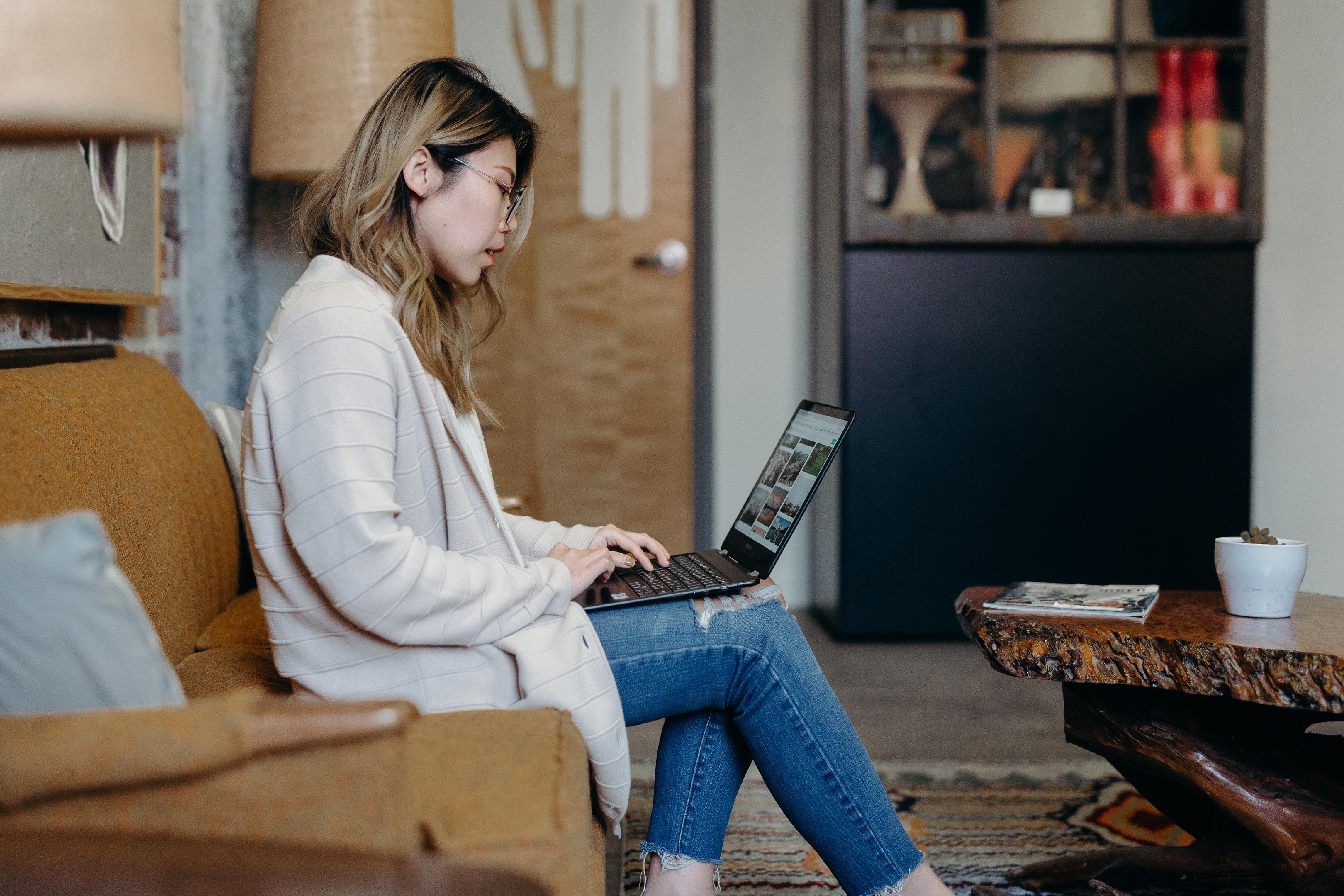 En kvinne som sitter på laptop