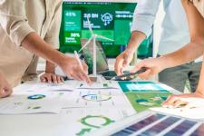 Fire personer peker på og diskuterer dokumenter om bærekraft