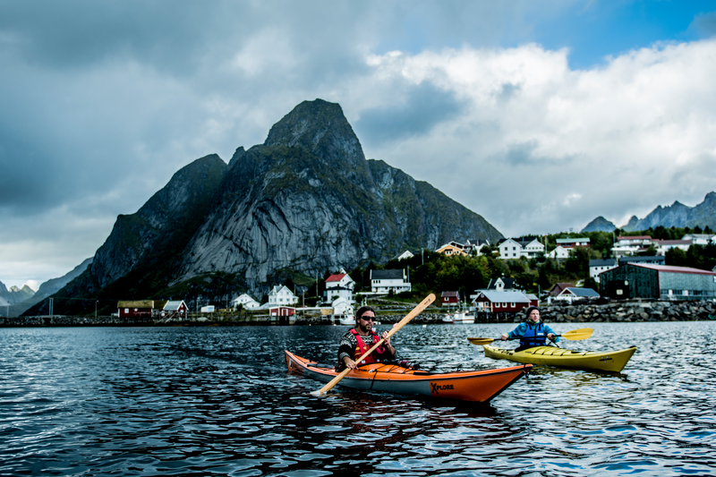 To kajakkpadlere på vei ut fra fiskeværet Reine i Lofoten