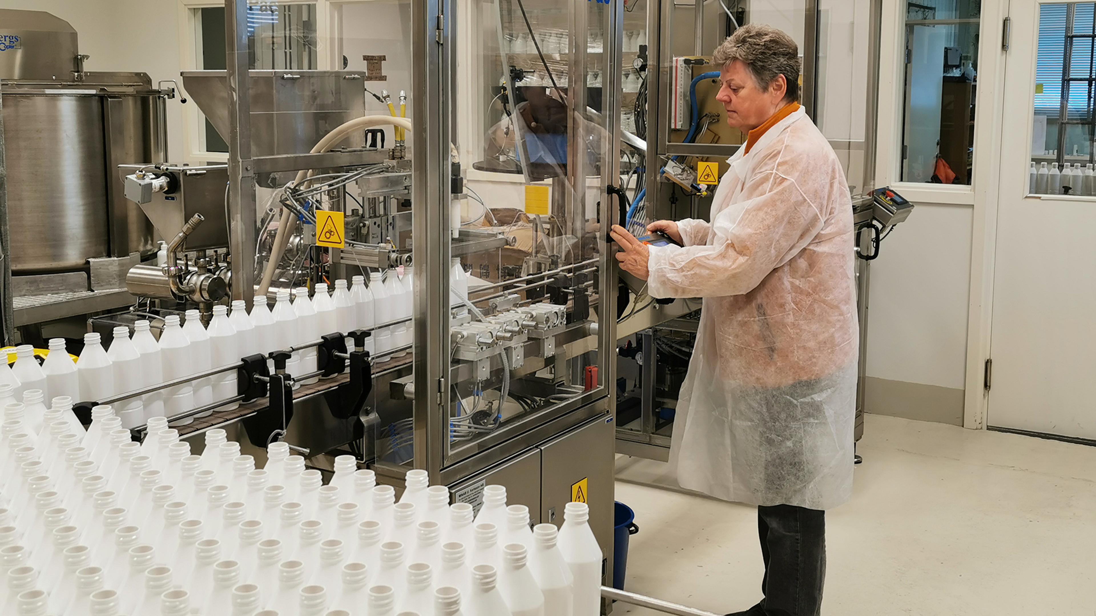 Forsker som jobber på laboratorium med flasker