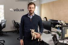 En mann står i et kontorlandskap og holder ei porselensku i hånda