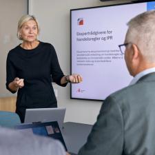 Kvinne presenterer ekspertrådgivere for handelsregler og IPR for to menn