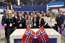 En gruppe mennesker med norske flagg rundt seg