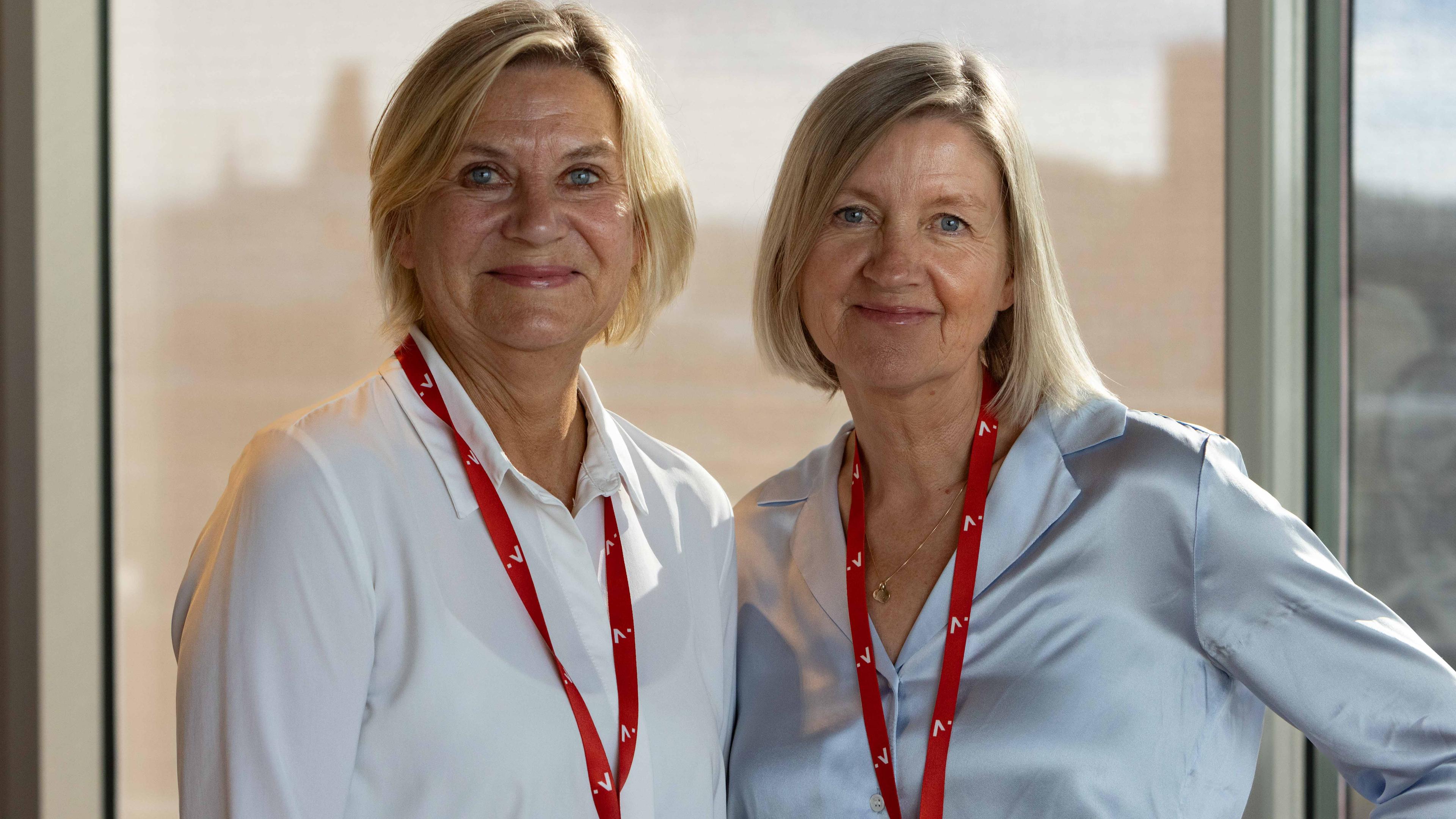 To kvinner smiler mot kameraet og har Innovasjon Norge-nøkkelbånd rundt halsen