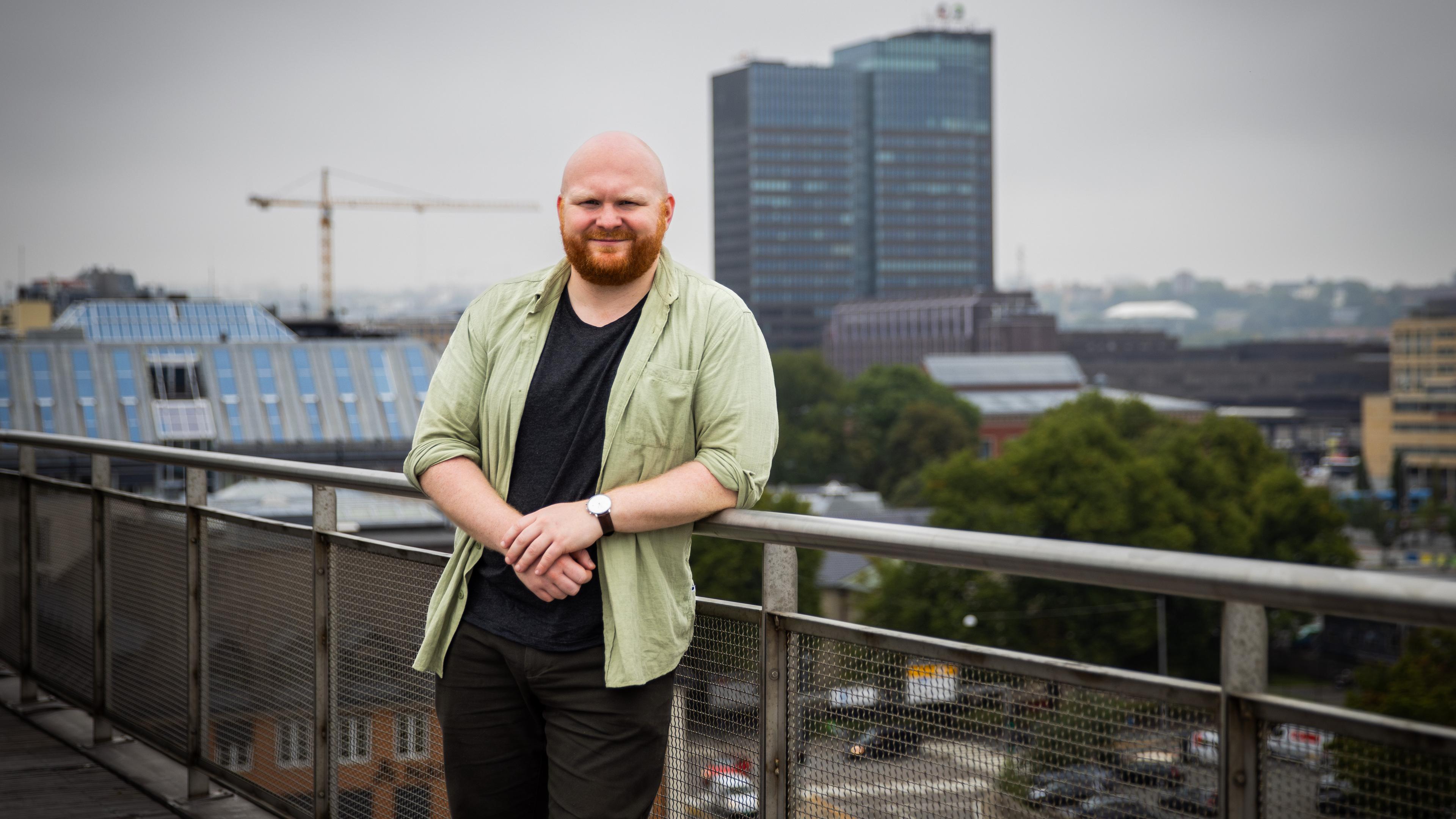 Geir Kulia står på en balkong med Oslo i bakgrunnen