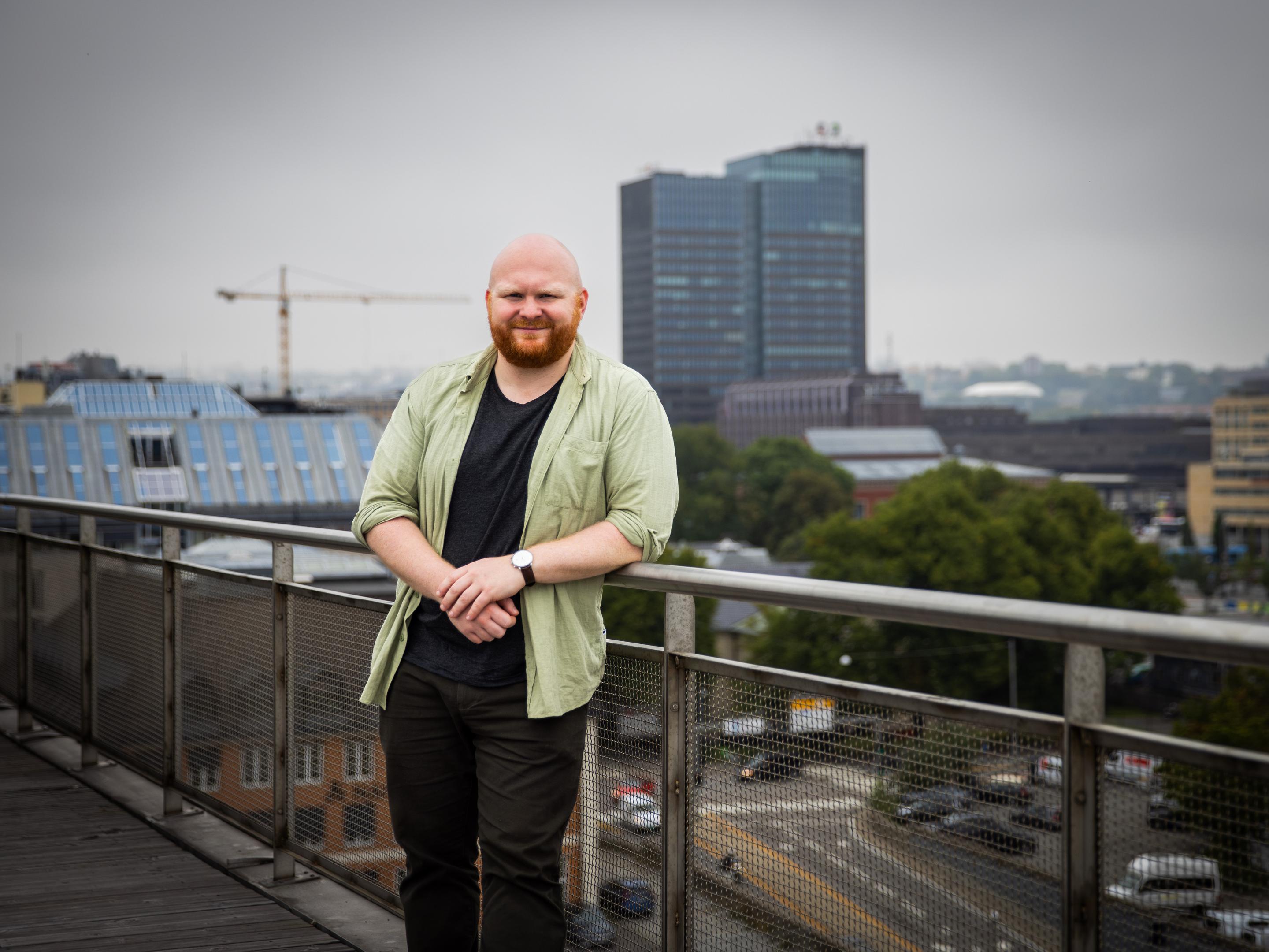 Geir Kulia står på en balkong med Oslo i bakgrunnen