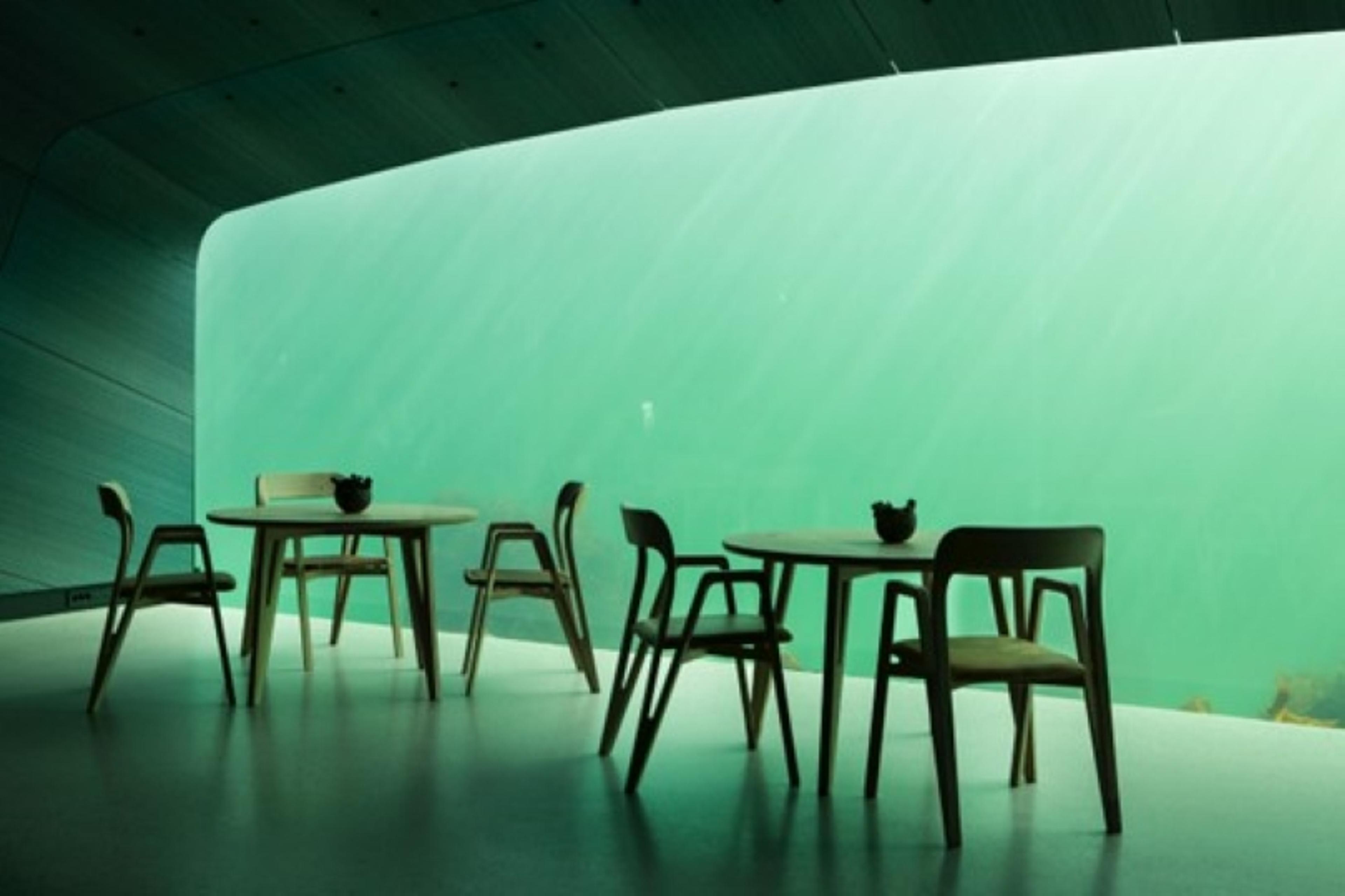 Designbord og -stoler på restauranten Under, med utsikt til under havet