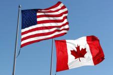 American and Canadian flag waving in the air