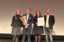 En kvinne og en mann fra Torvholen gård viser frem prisen sammen med de som delte den ut