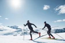 En kvinne og mann går på ski på fjellet i utstyr fra merkevaren Rottefella