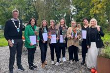 De seks Åkerkvinnene som har mottatt beviset på at de er vinner av bedriftsutviklingsprisen for Vestfold og Telemark i 2023. Sammen med ordføreren i Larvik og regiondirektøren i Innovasjon Norge.