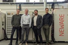 Fire menn står ved iden av hverandre i et teknisk rom