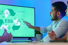 En mann peker på en skjerm med en presentasjon av ESG