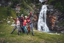 Family biking by a waterfall