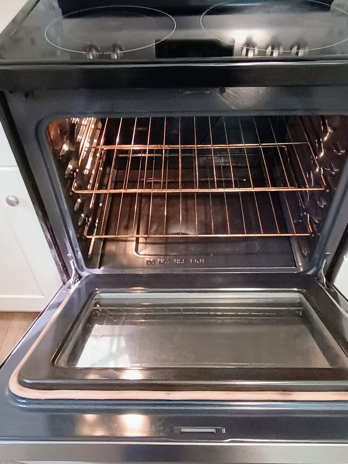 The inside of an open oven with clean racks.