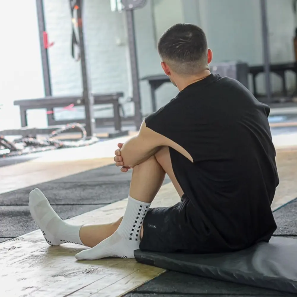 Joven entrenando en un gimnasio con medias antideslizantes