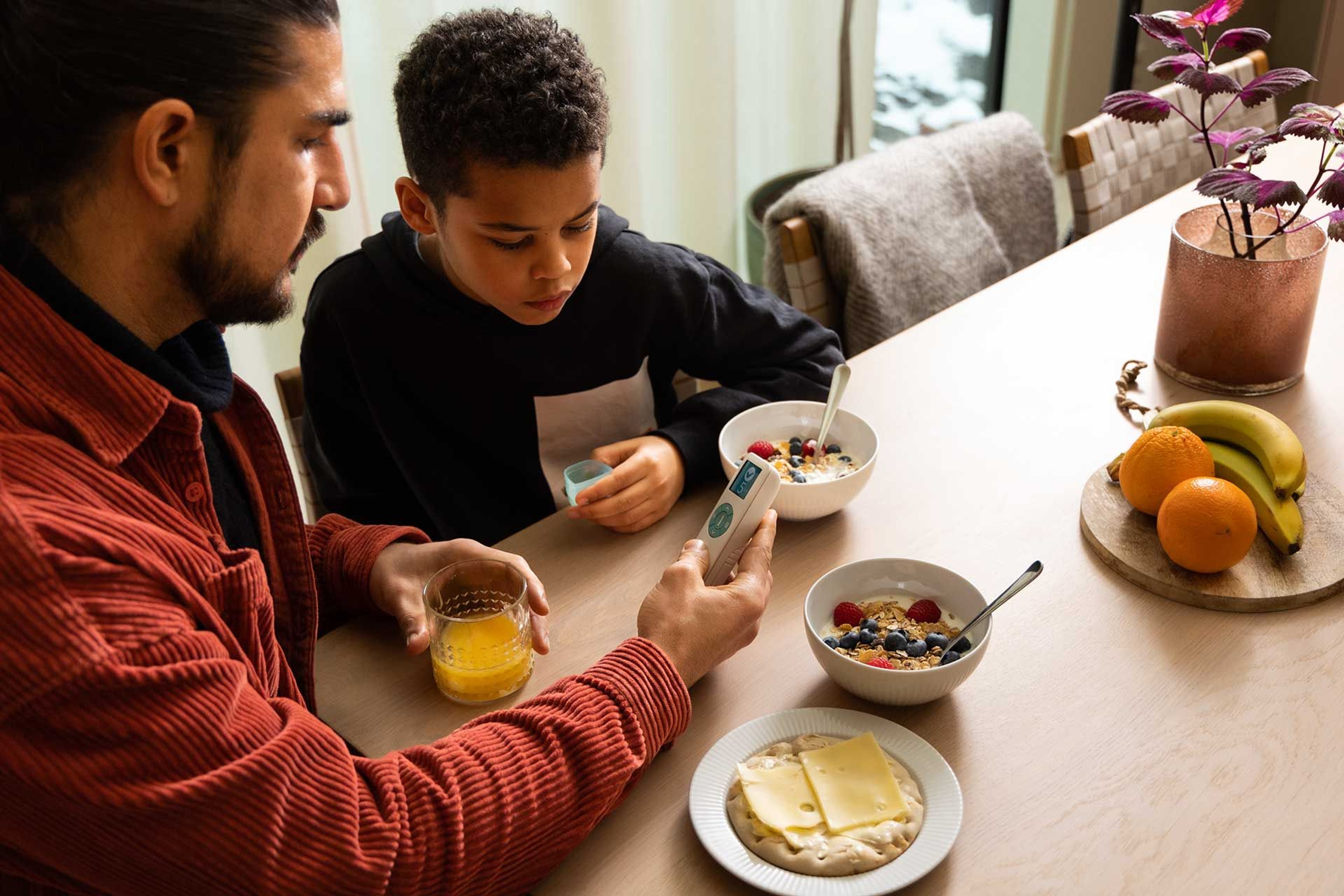 A father and son eating breakfast and uses the OnDosis