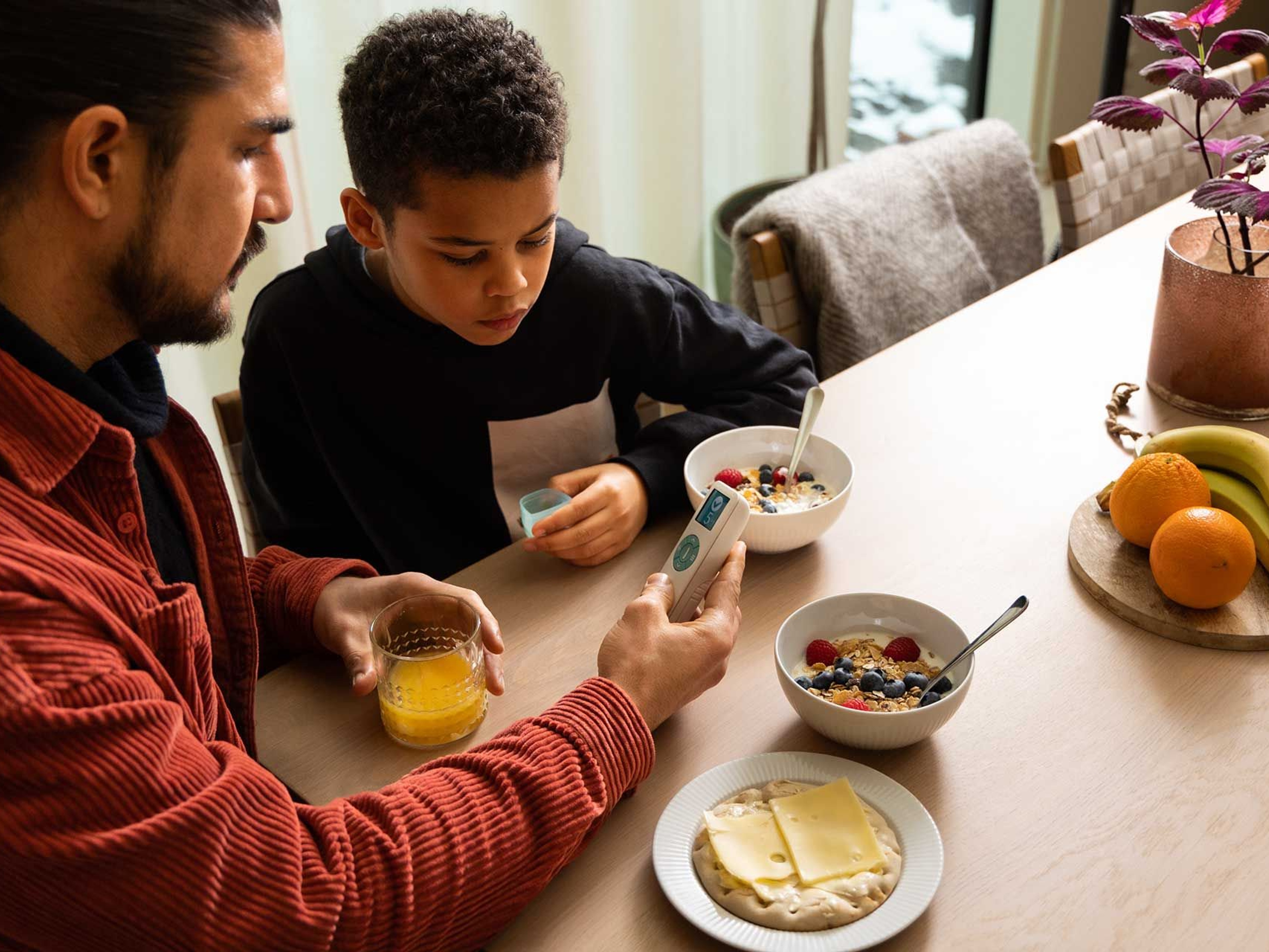 A father and son eating breakfast and uses the OnDosis