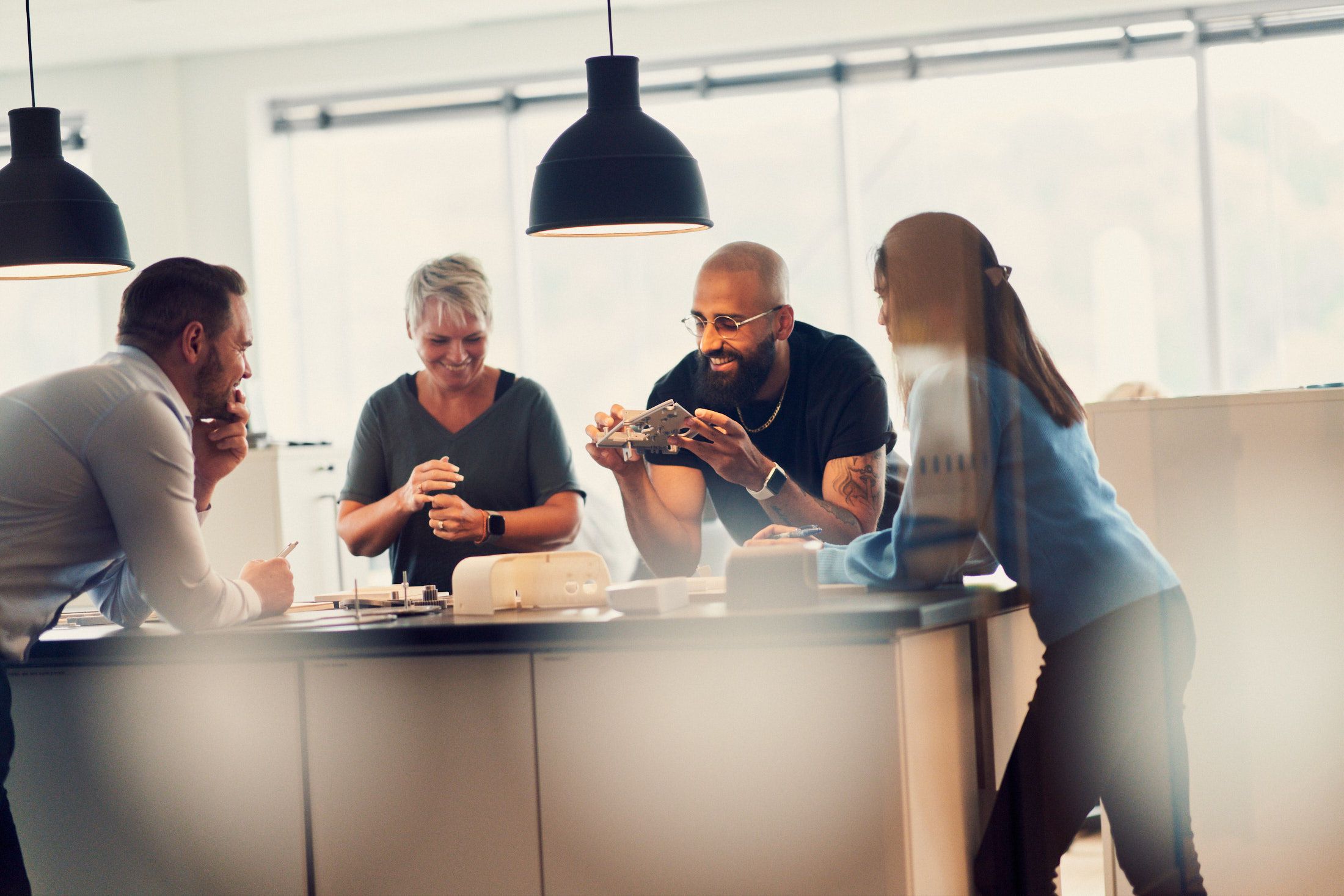 A group of people collaborating around a table with prototypes