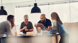 A group of people collaborating around a table with prototypes