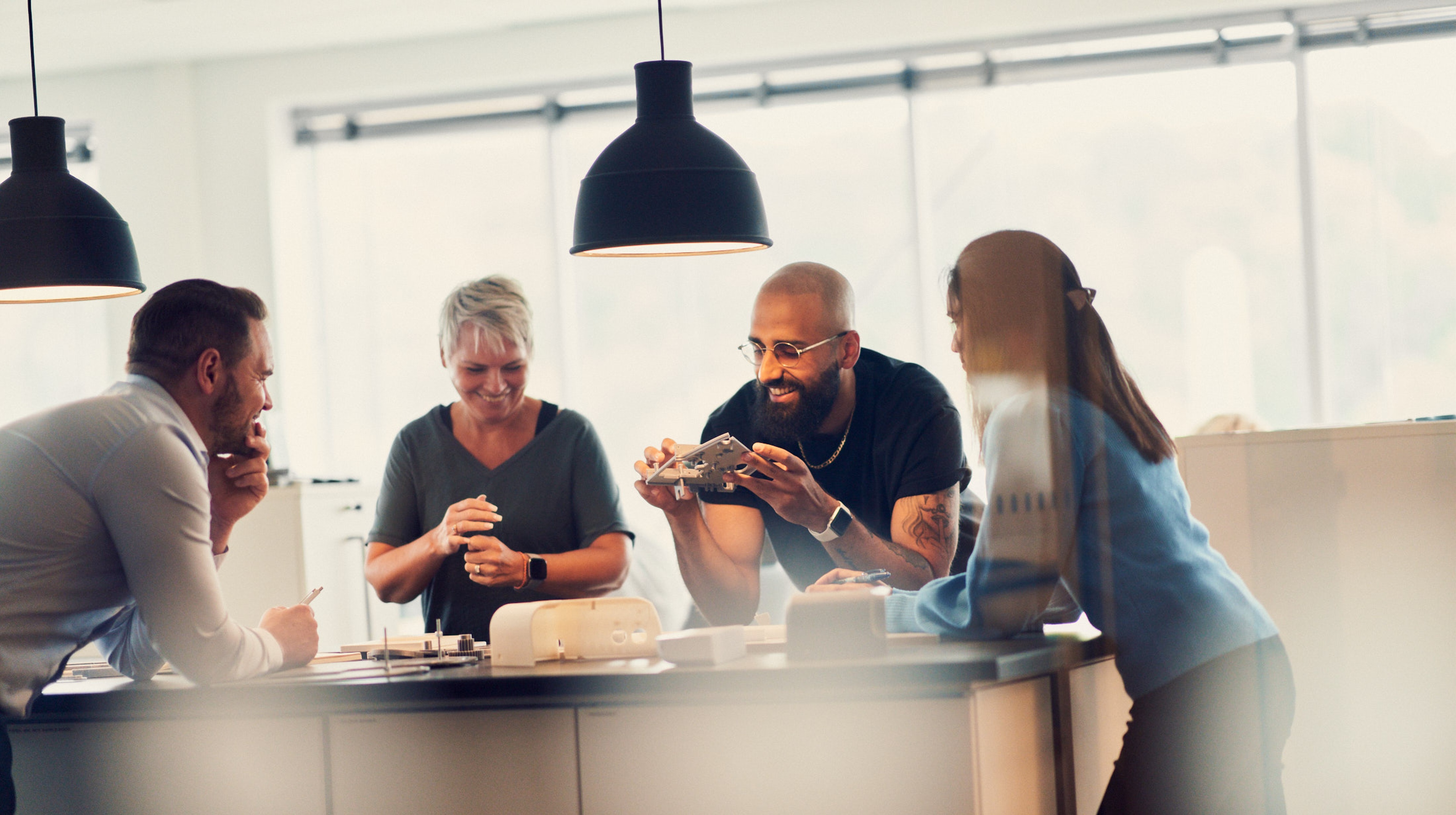 A group of people collaborating around a table with prototypes