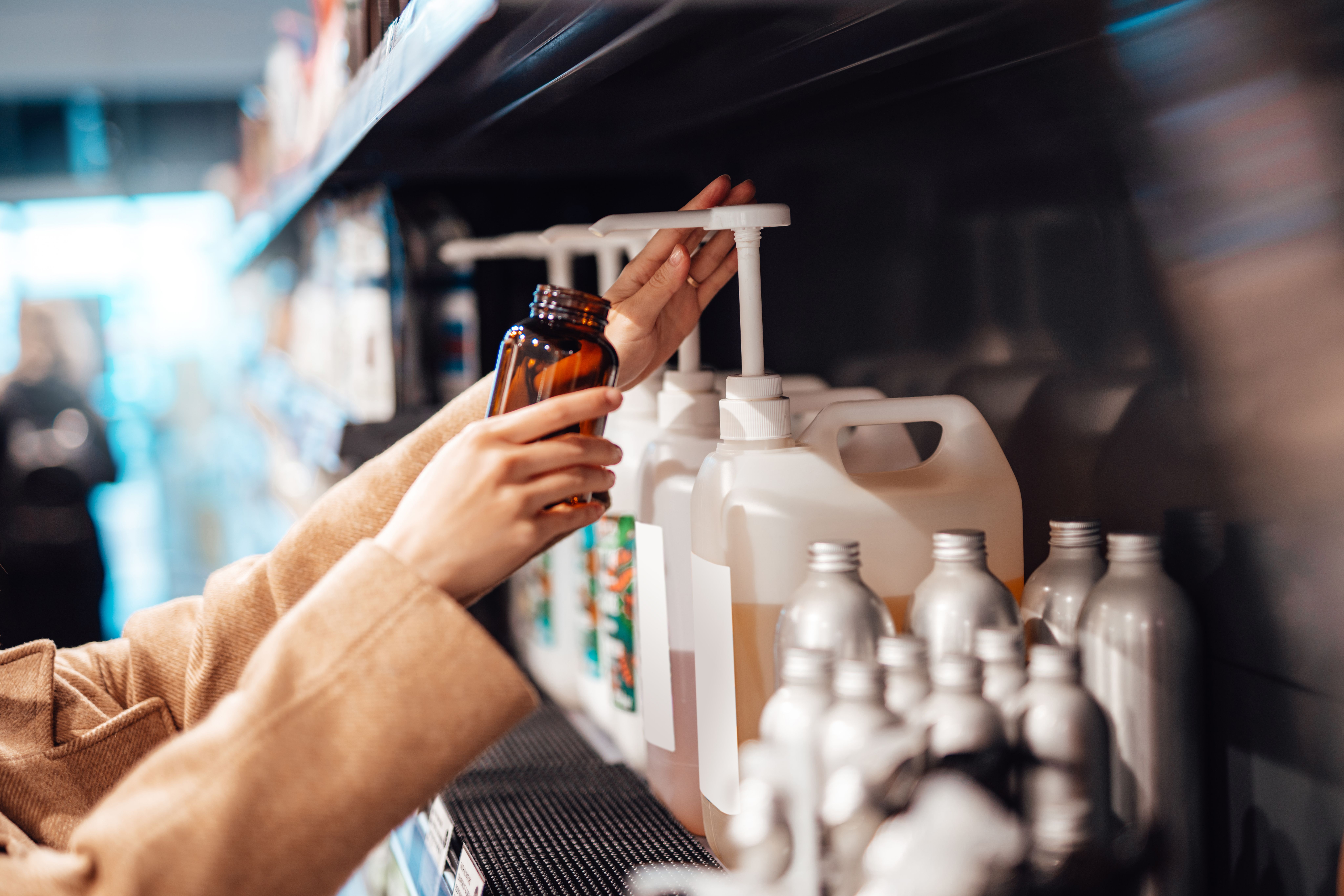 Person filling up a bottle with soap