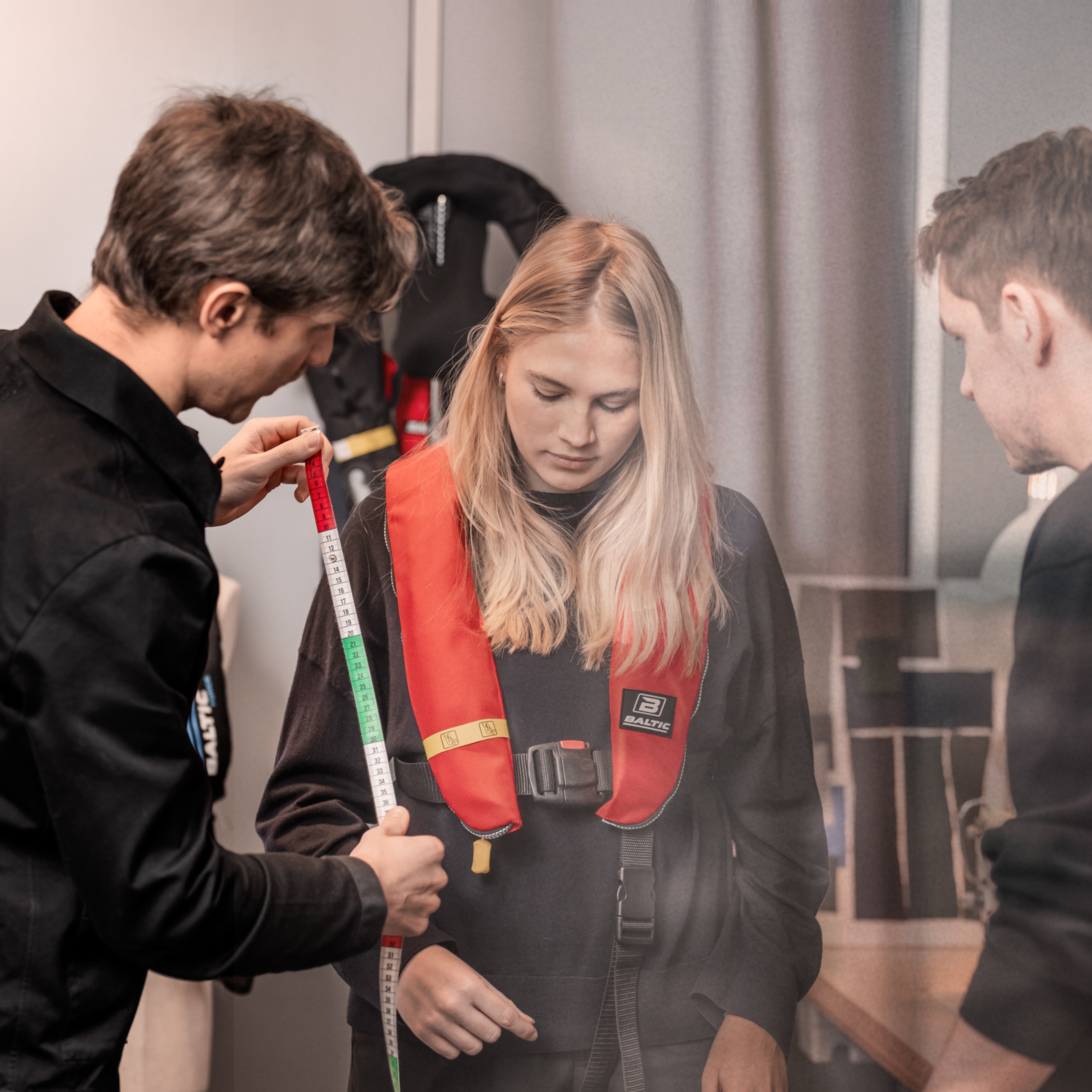 Tre personer jobbat med en flytväst.