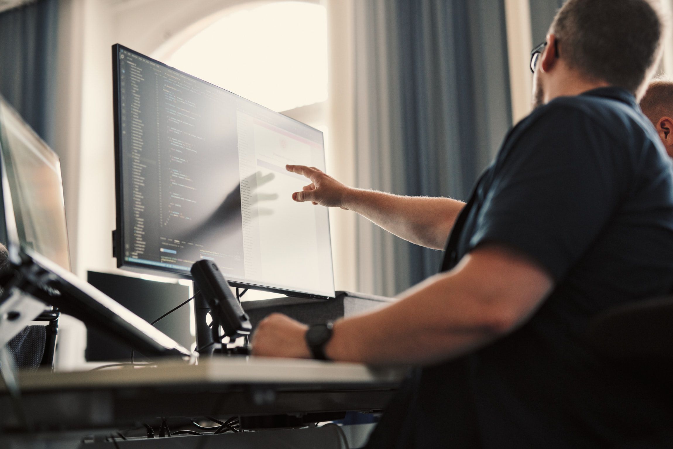 A man pointing at a computer screen
