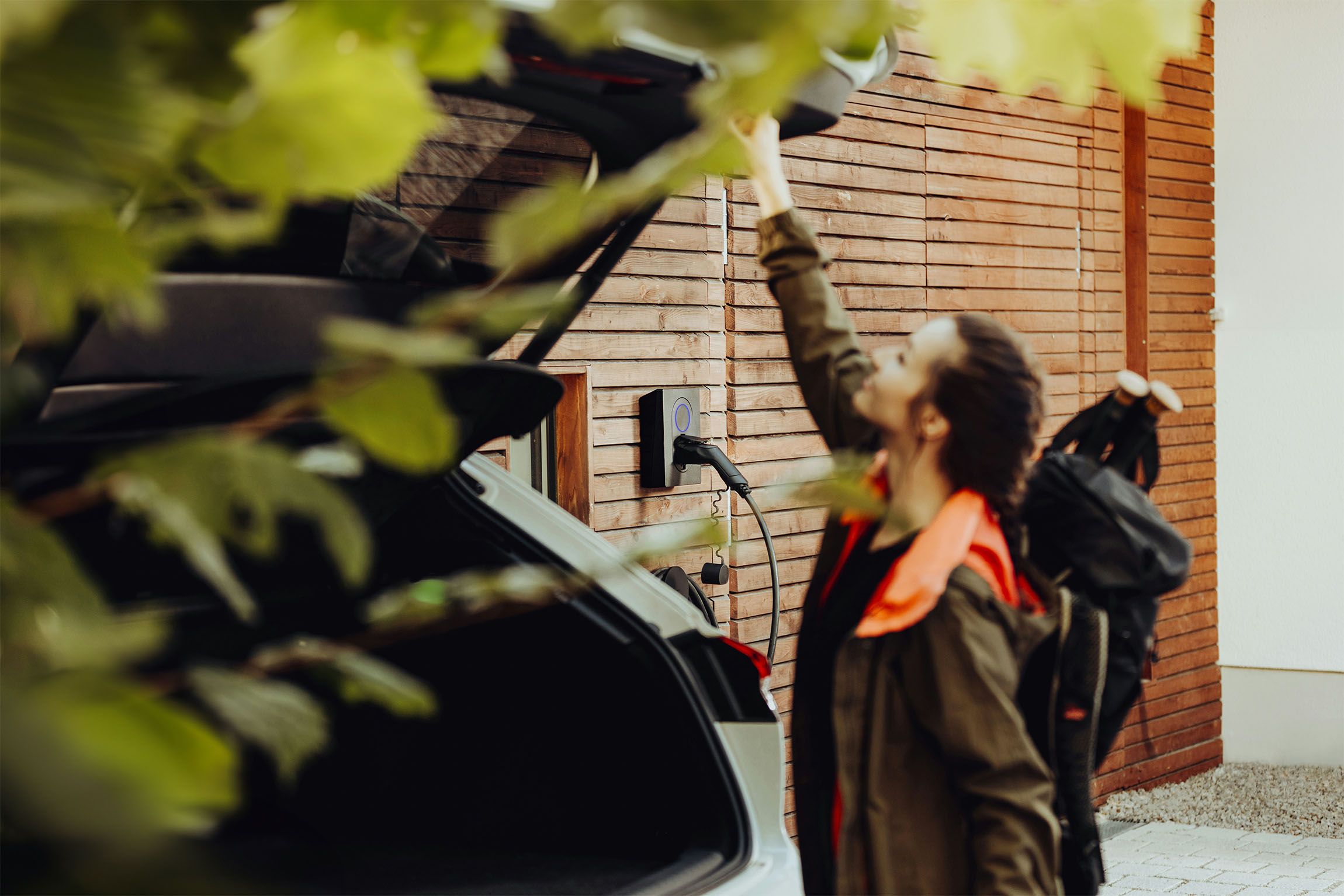A woman closing the trunk of an electric car