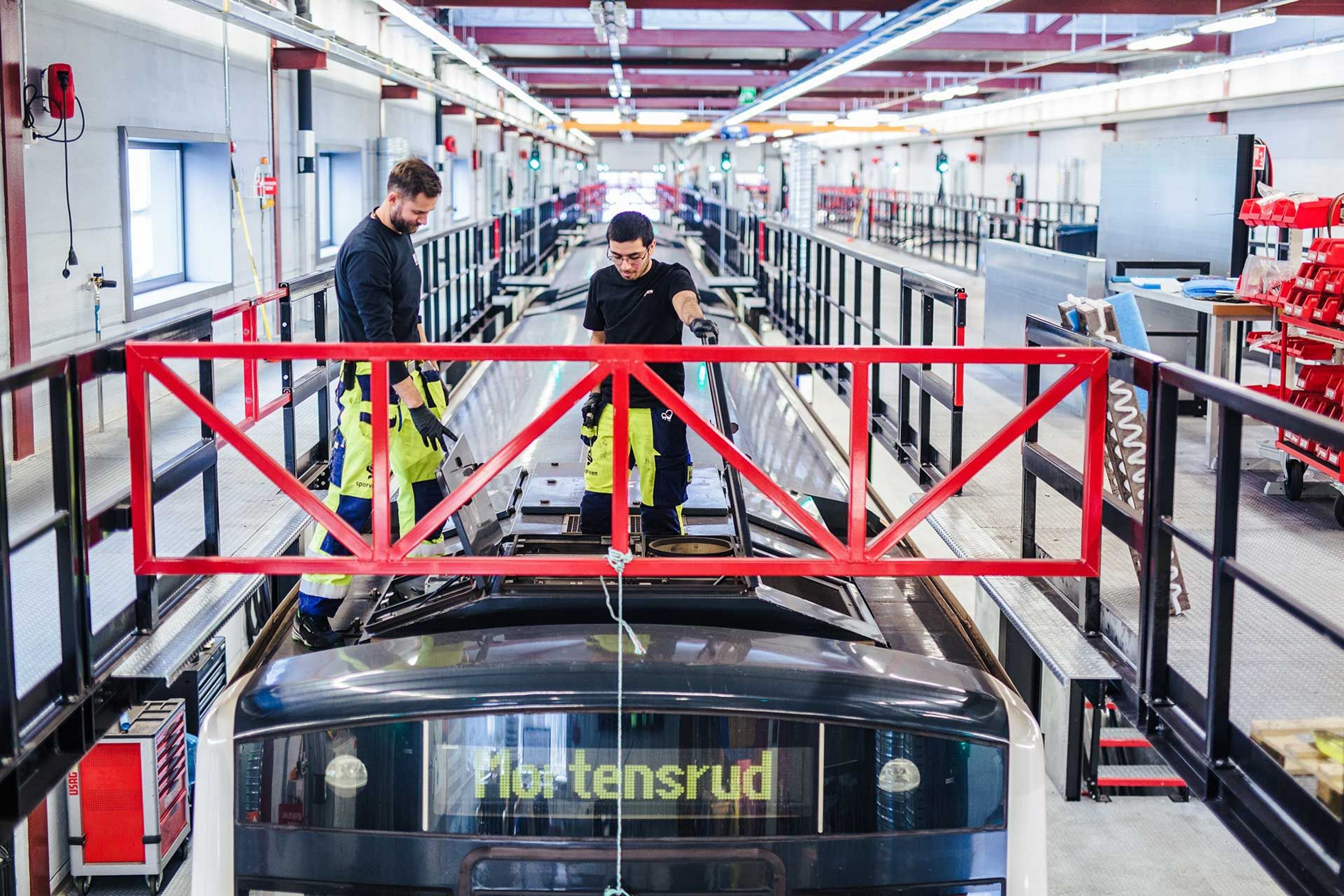 Two men working on top of a train