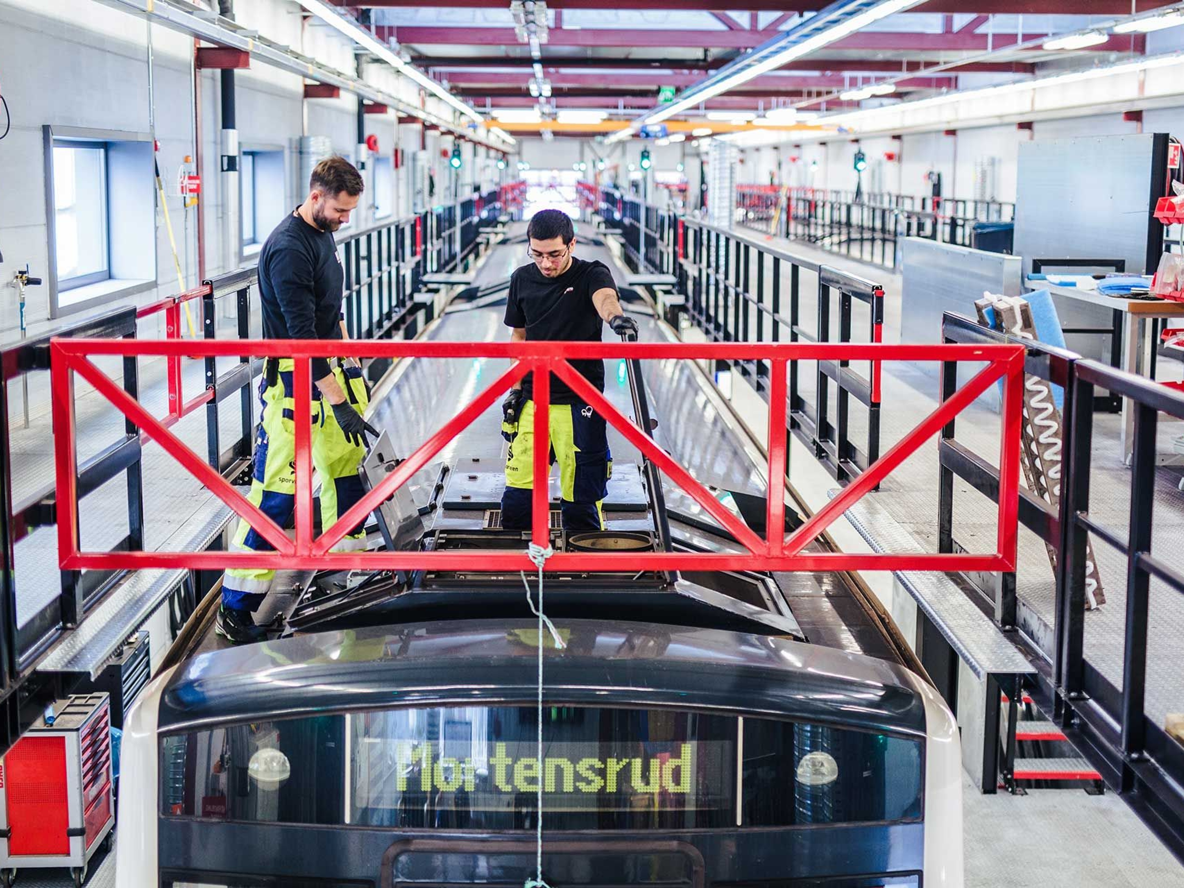 Two men working on top of a train