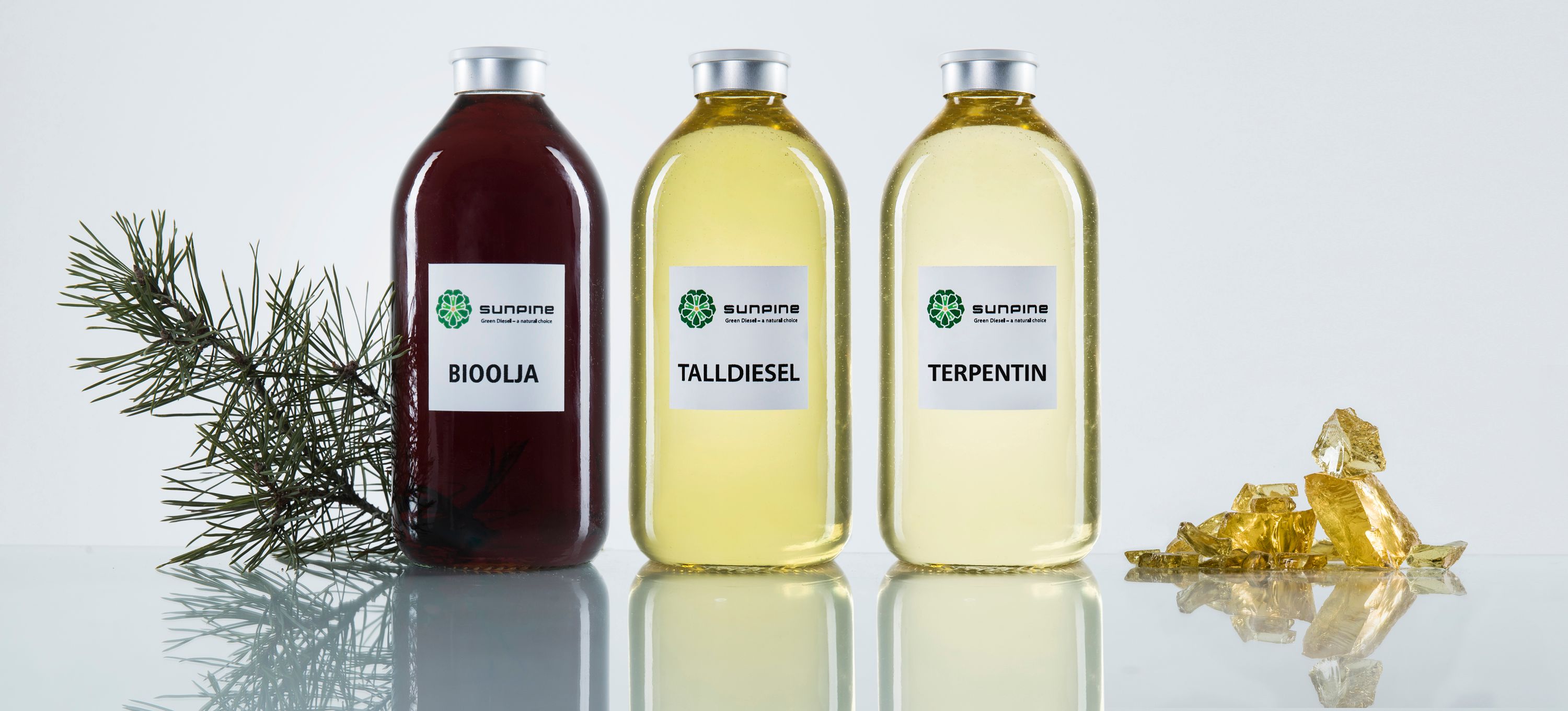 Bottles containing bio-based liquids derived from pine, labeled for different products.
