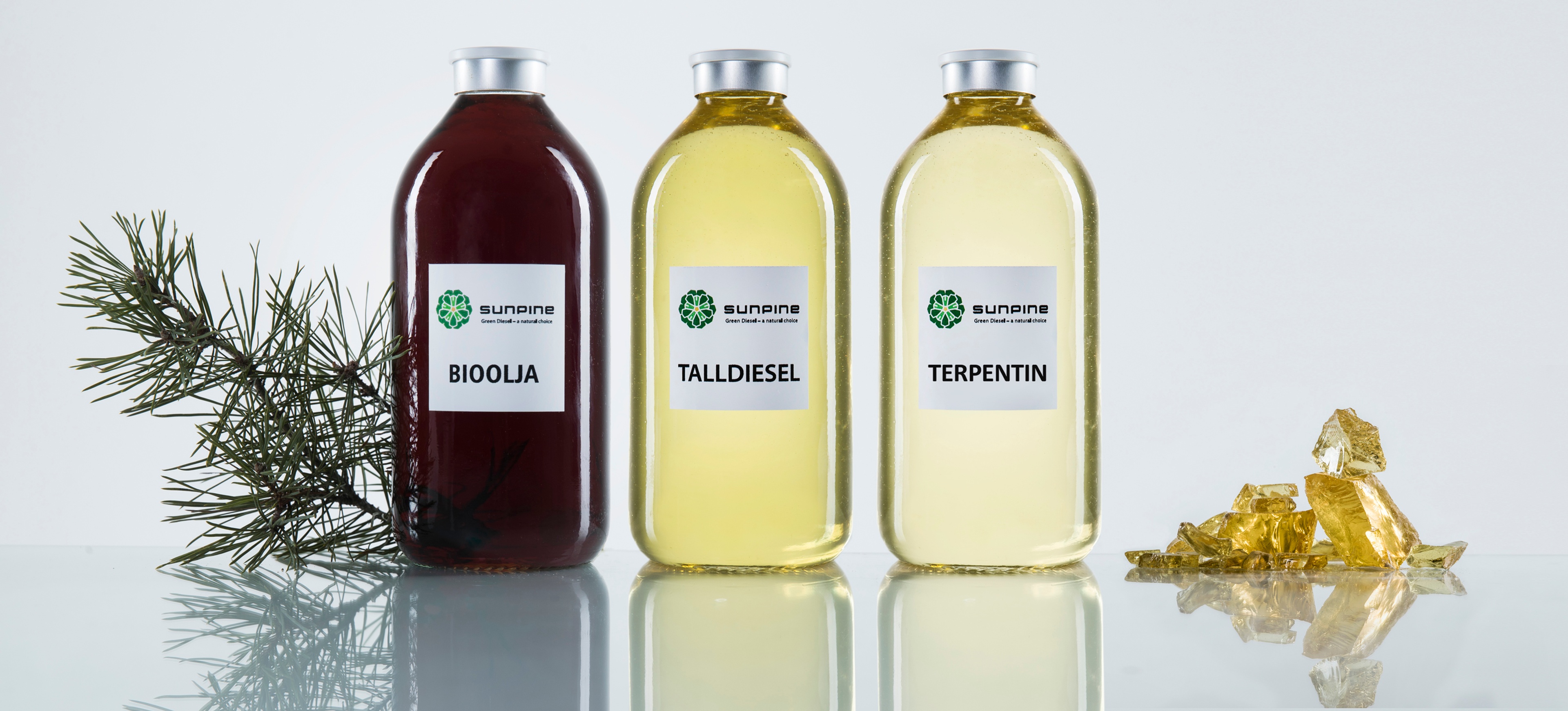 Bottles containing bio-based liquids derived from pine, labeled for different products.
