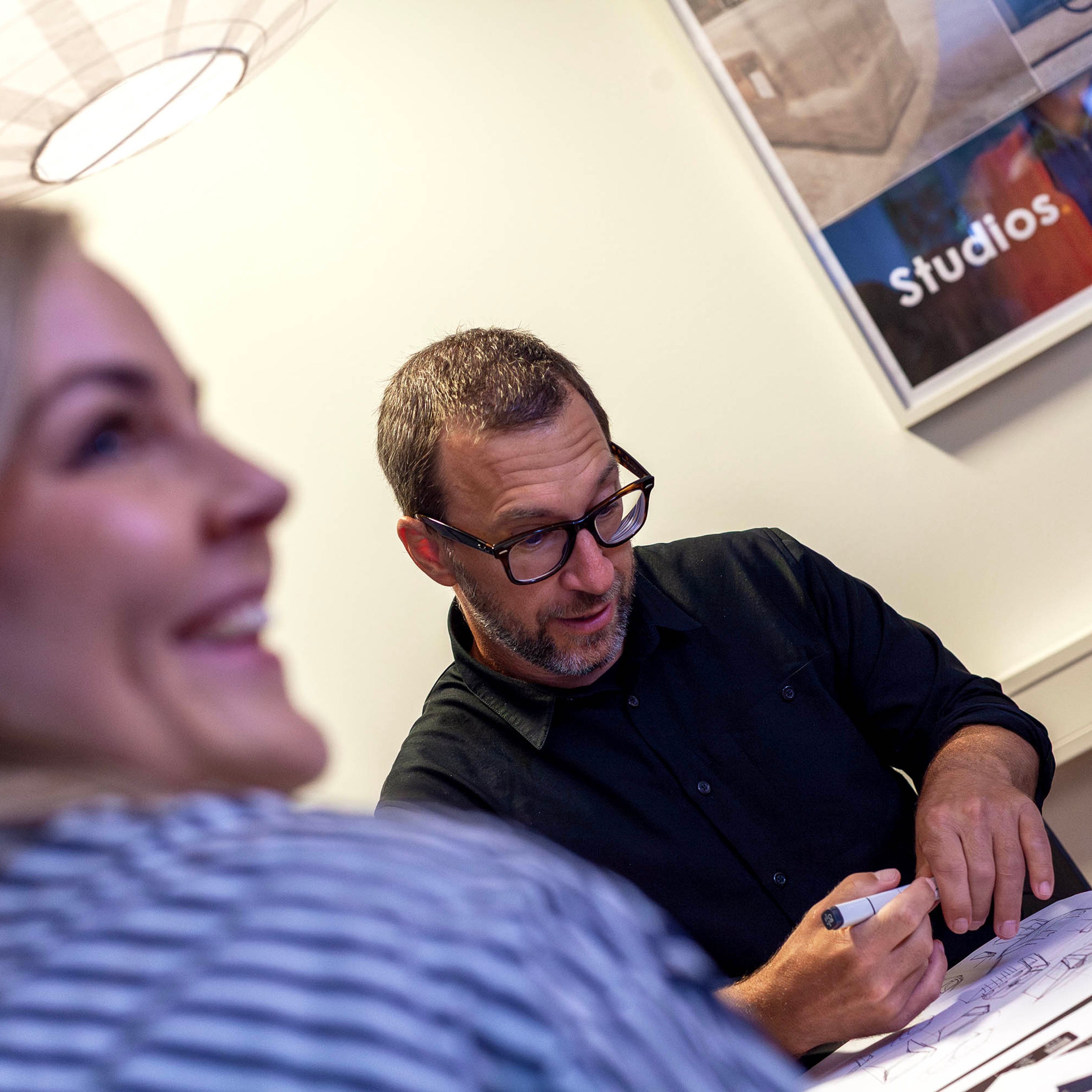 Two people sketching on paper.
