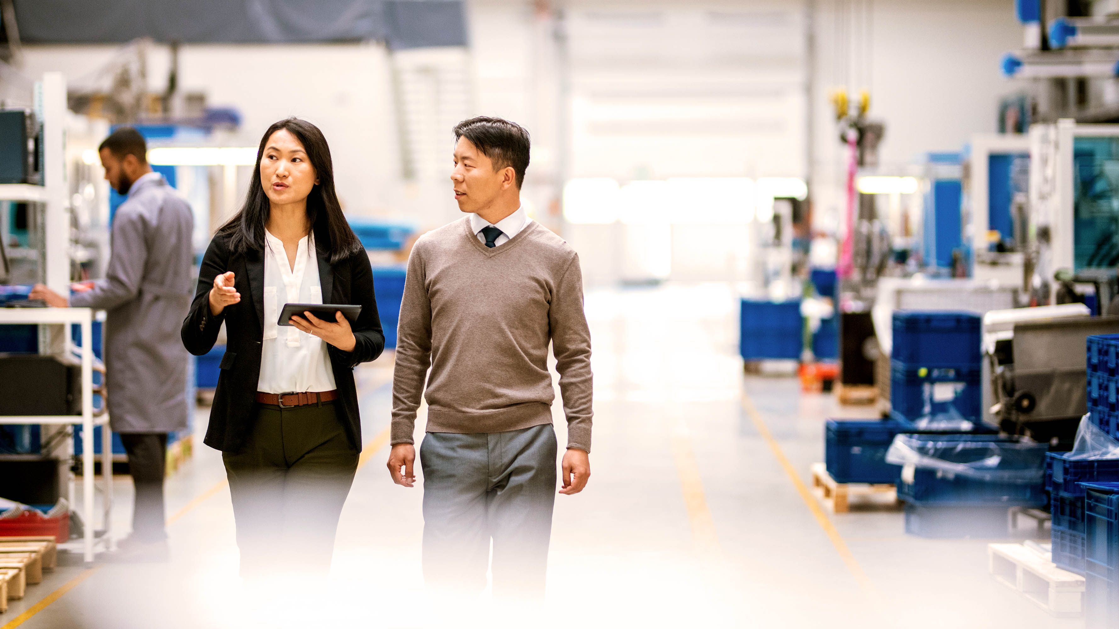 Two people walking and talking in a factory