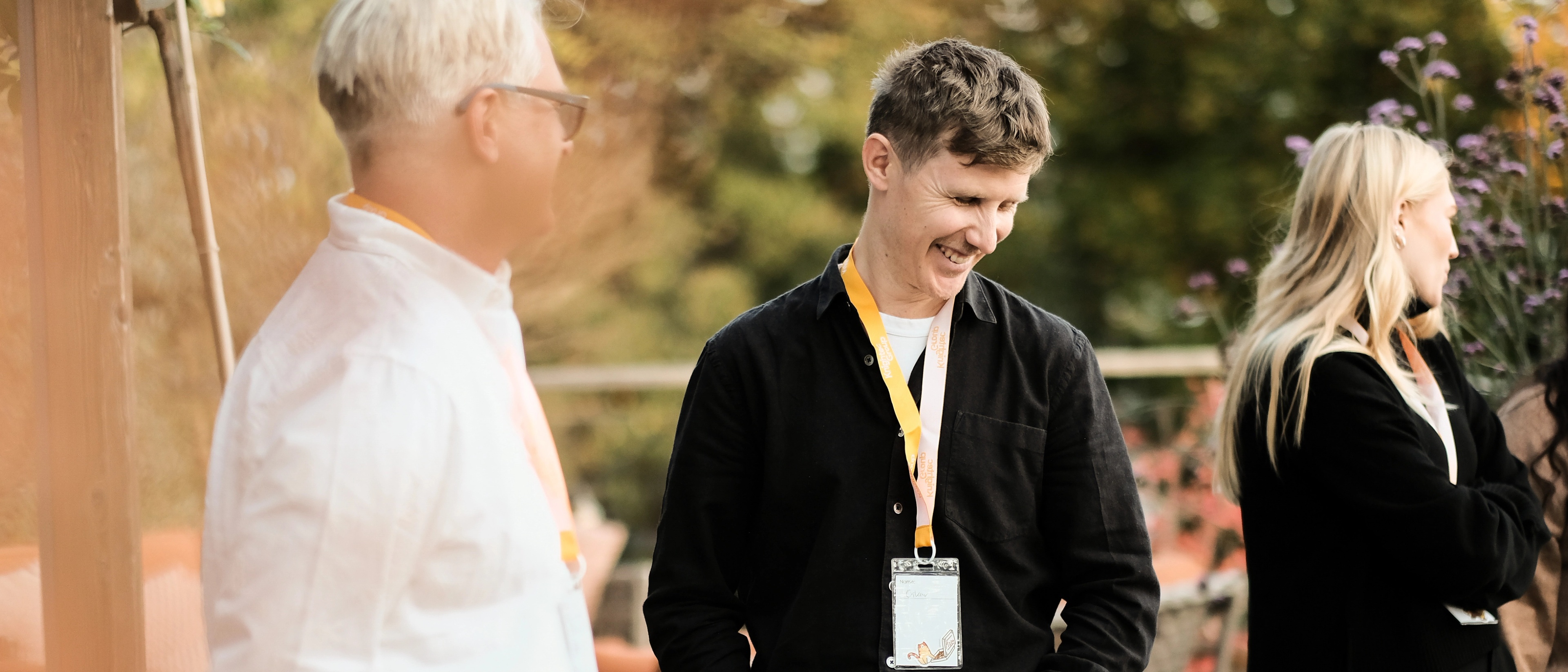 Three people standing in an outside setting at an event