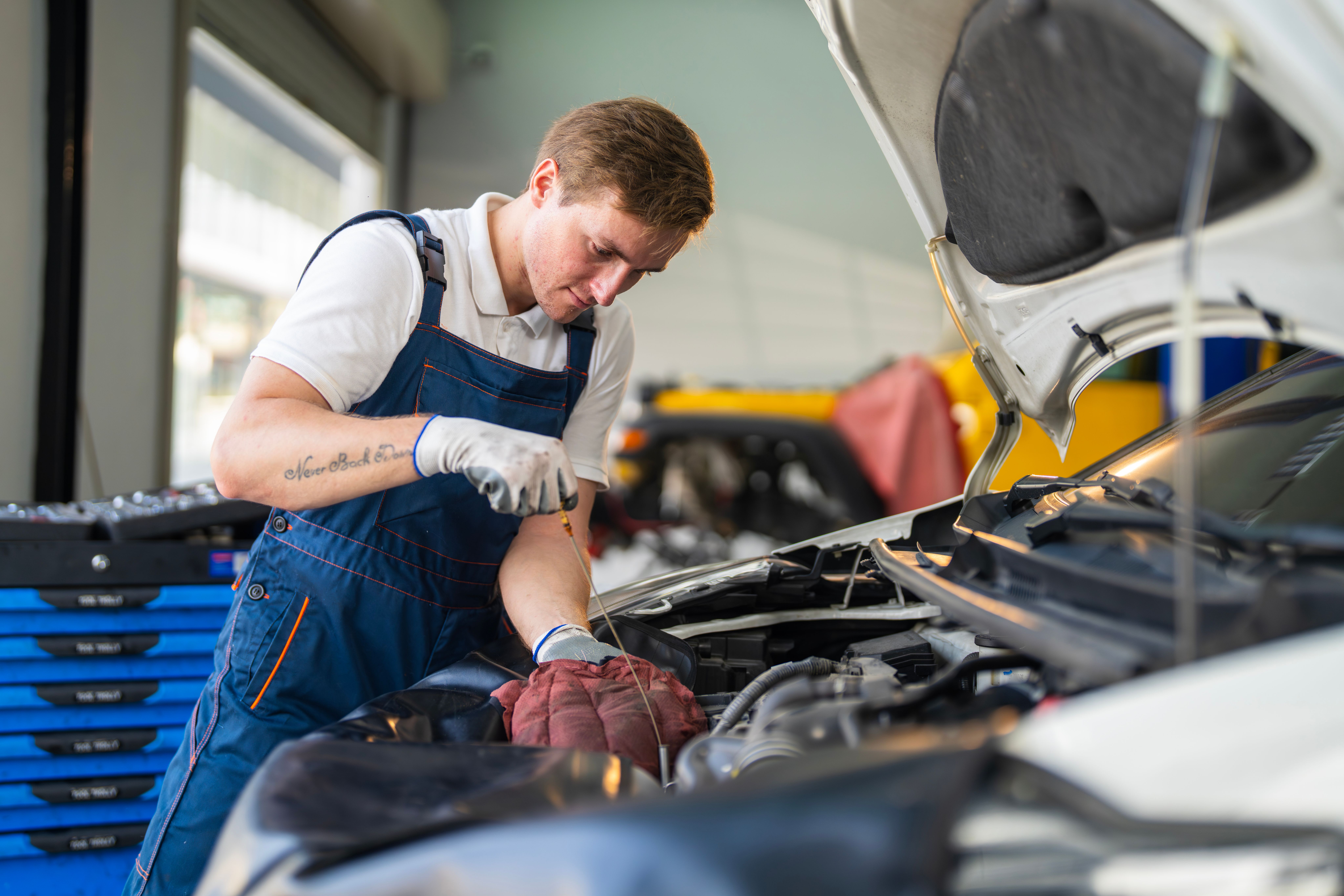 Person checking oil level on a car.