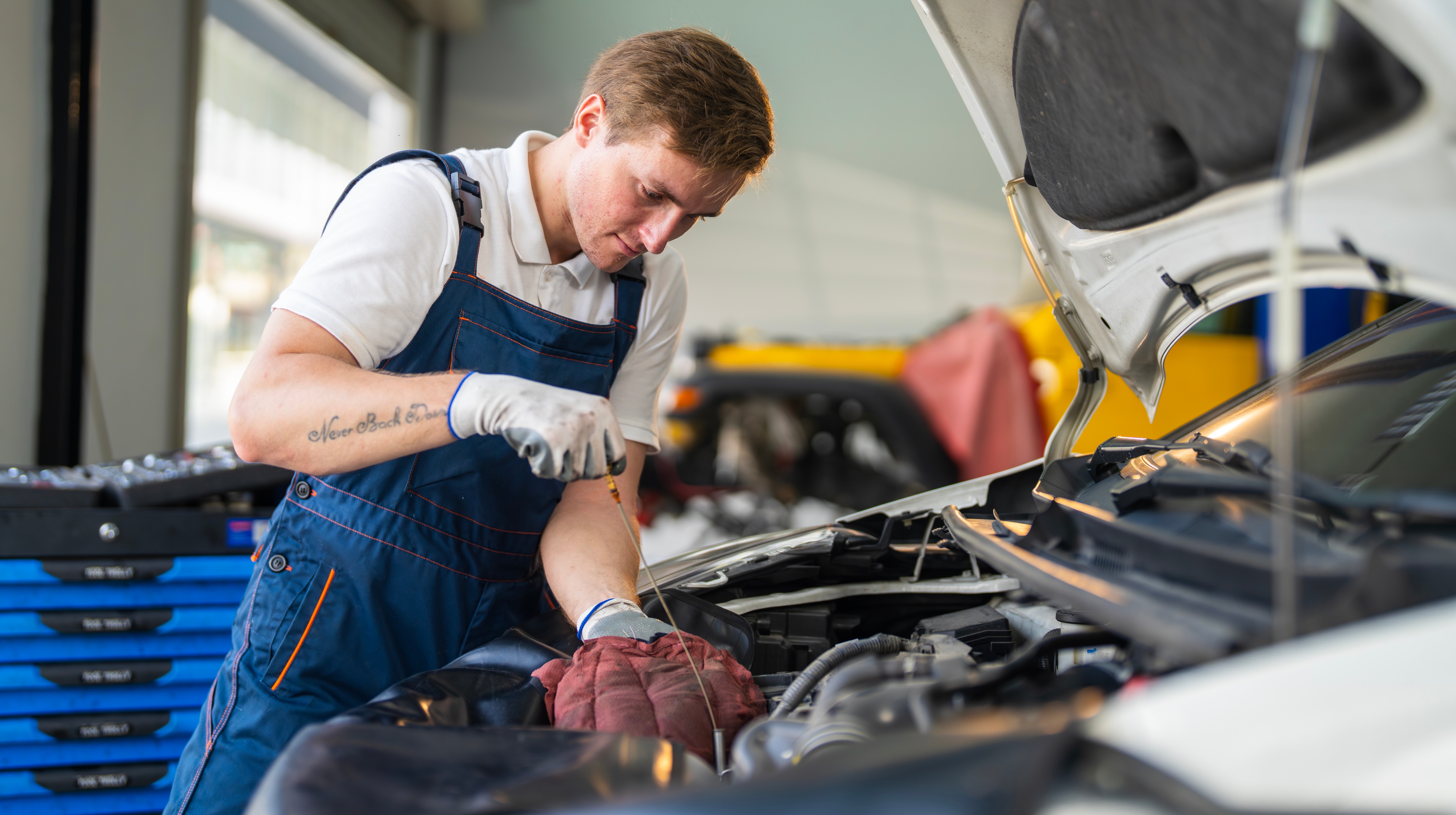 Person checking oil level on a car.