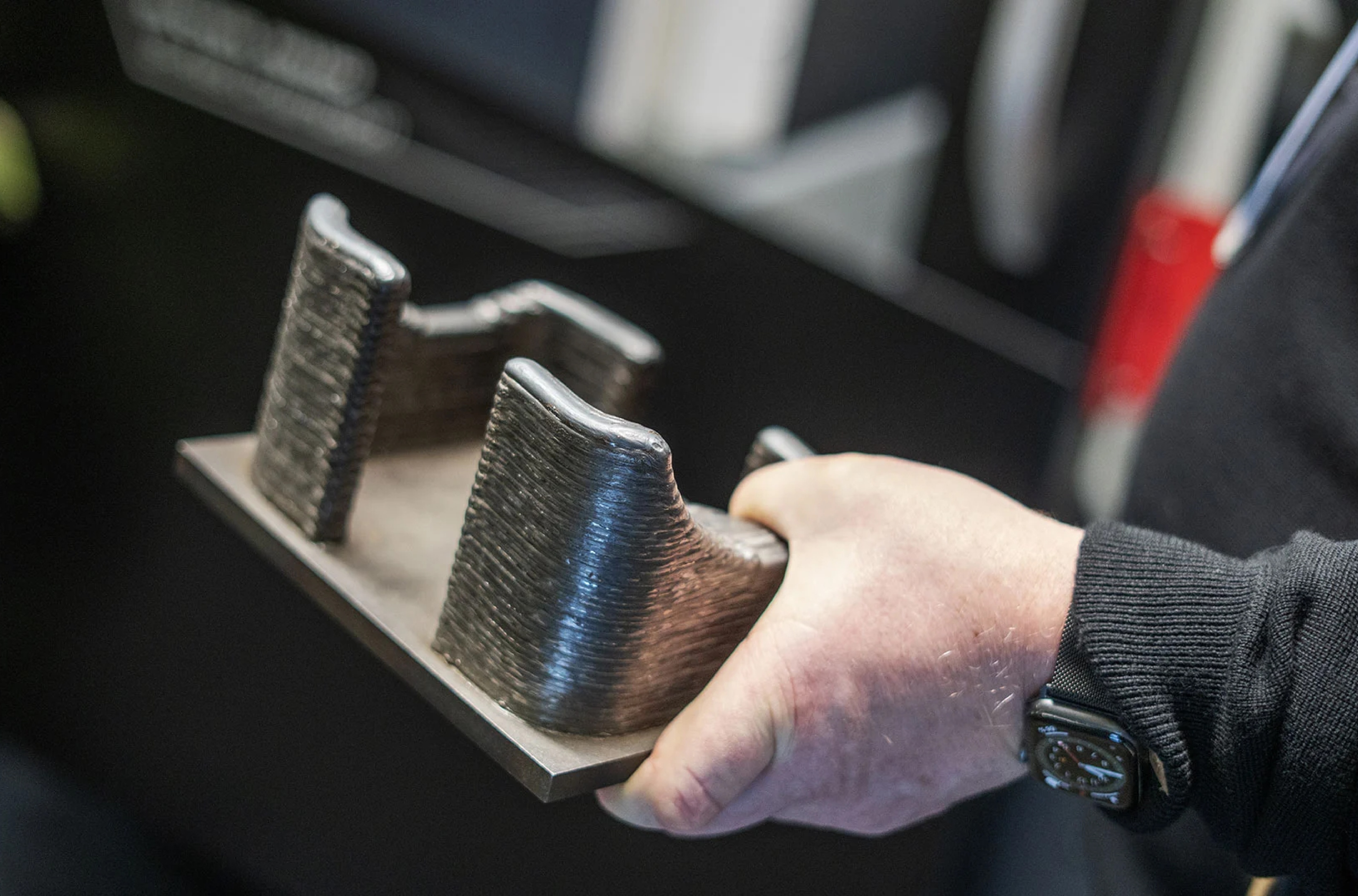 Uma pessoa segurando uma peça impressa em 3D