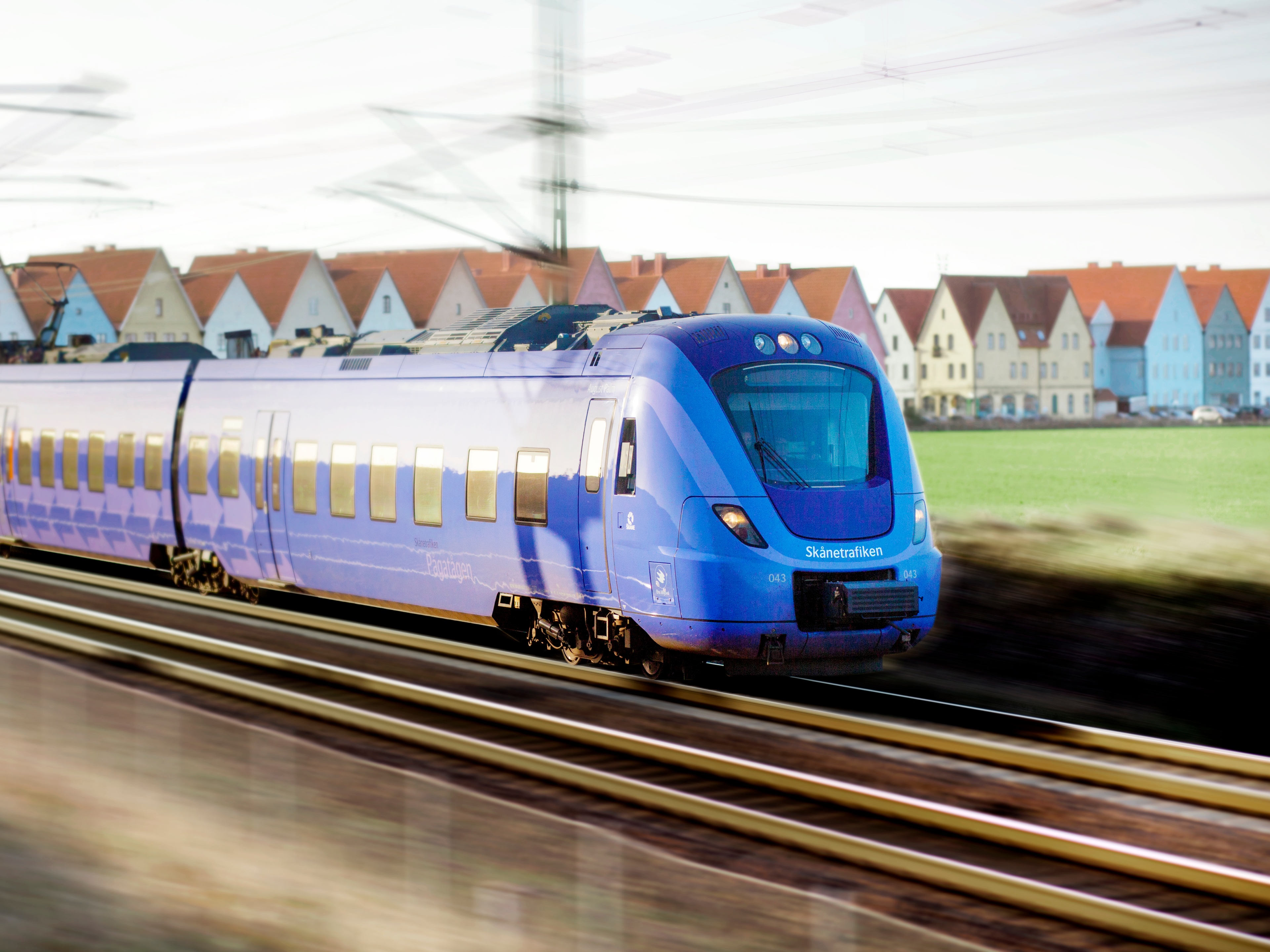Passenger train traveling through a rural landscape.