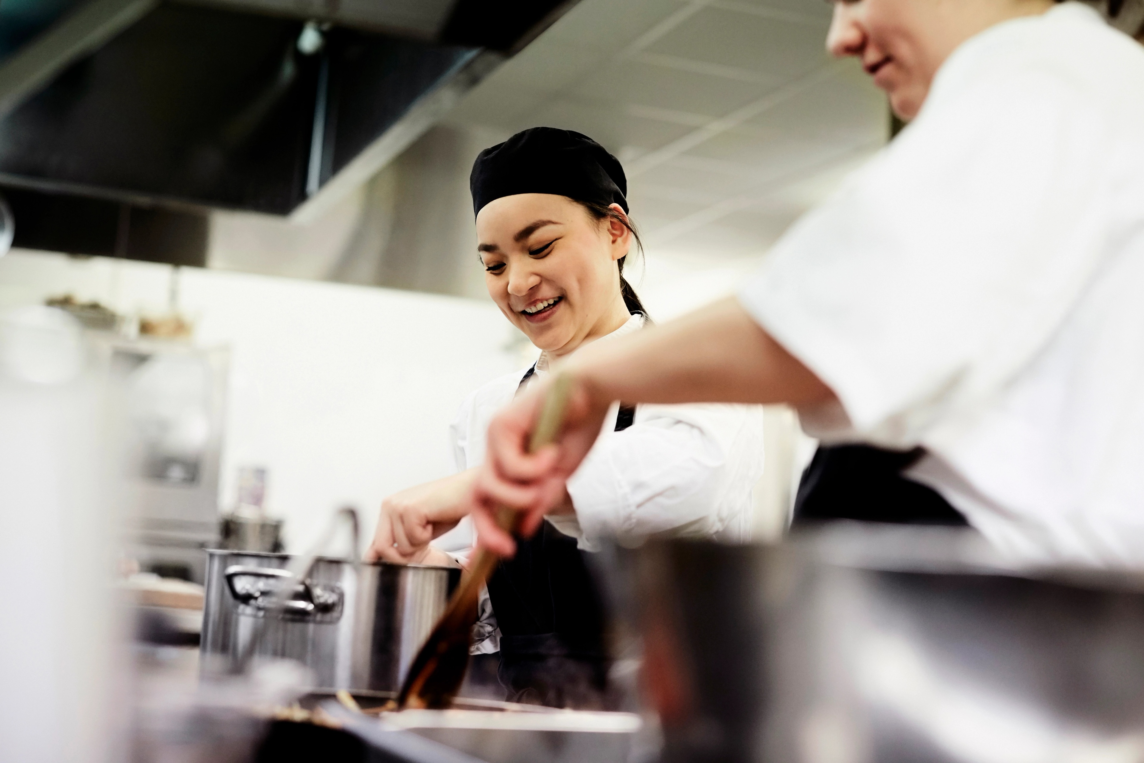 Chefs preparing food together in a professional kitchen.