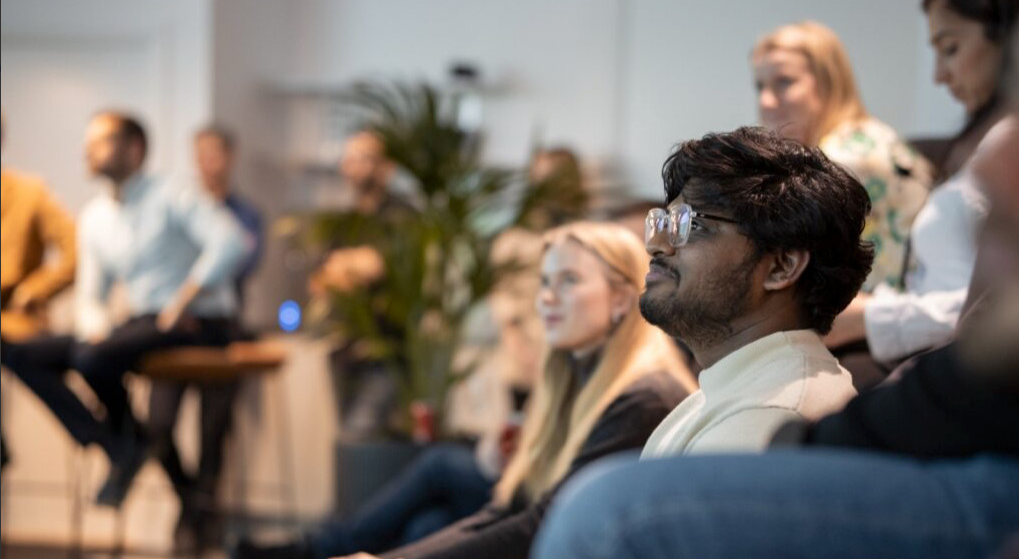 A group of people sitting down and facing the same direction