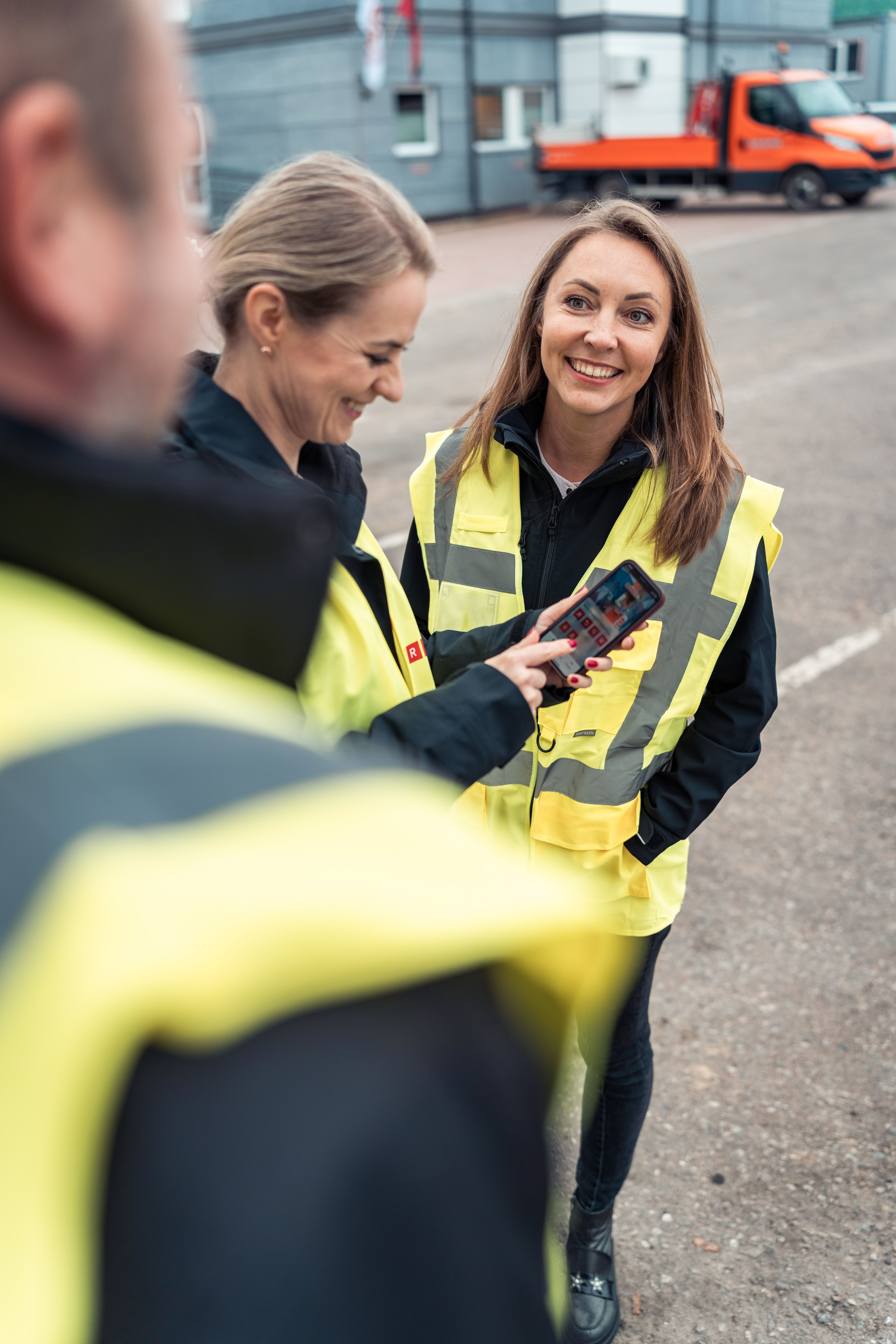 Three persons looking at a cell phone